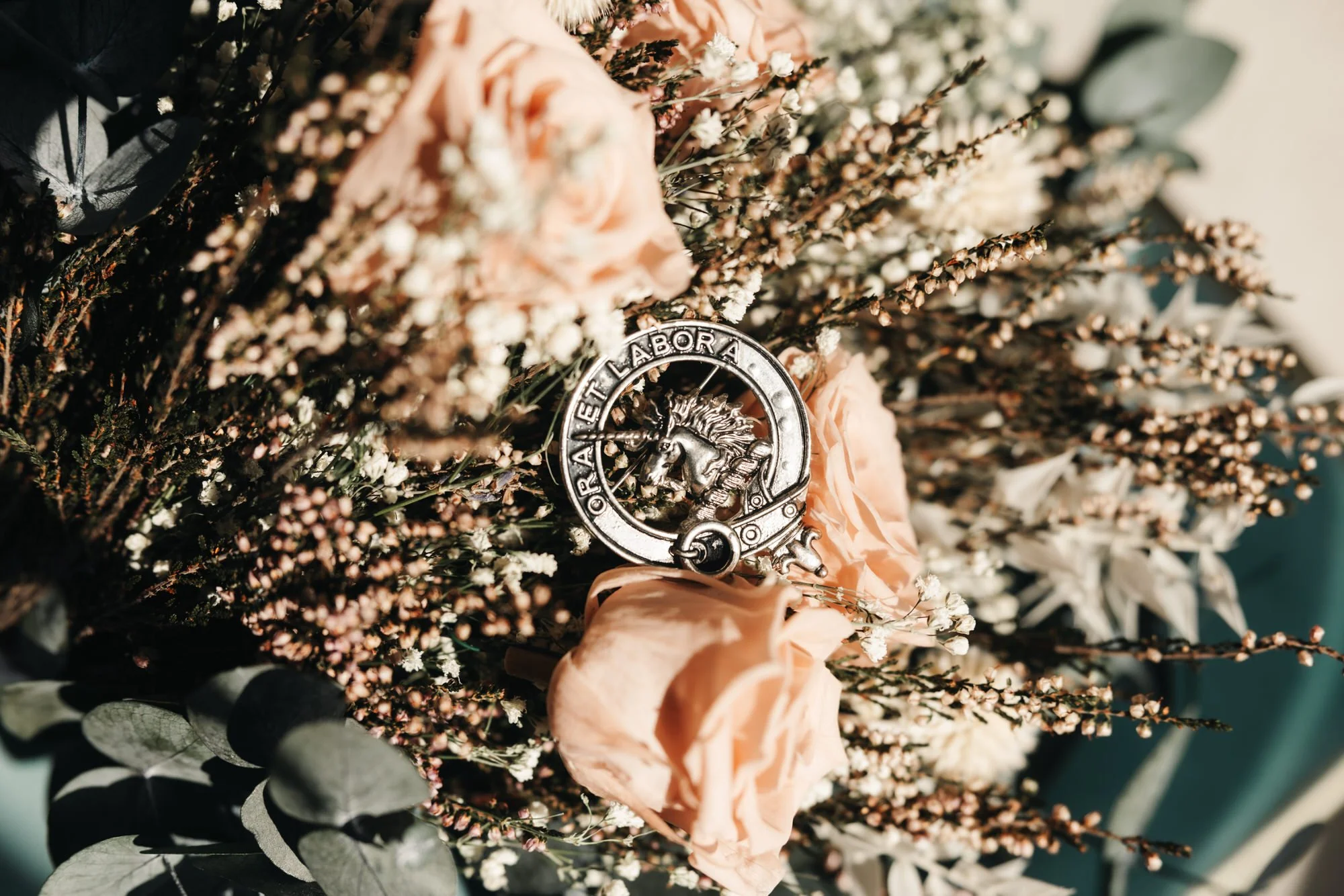 Dried wedding bouquet beside a silver sporran detail