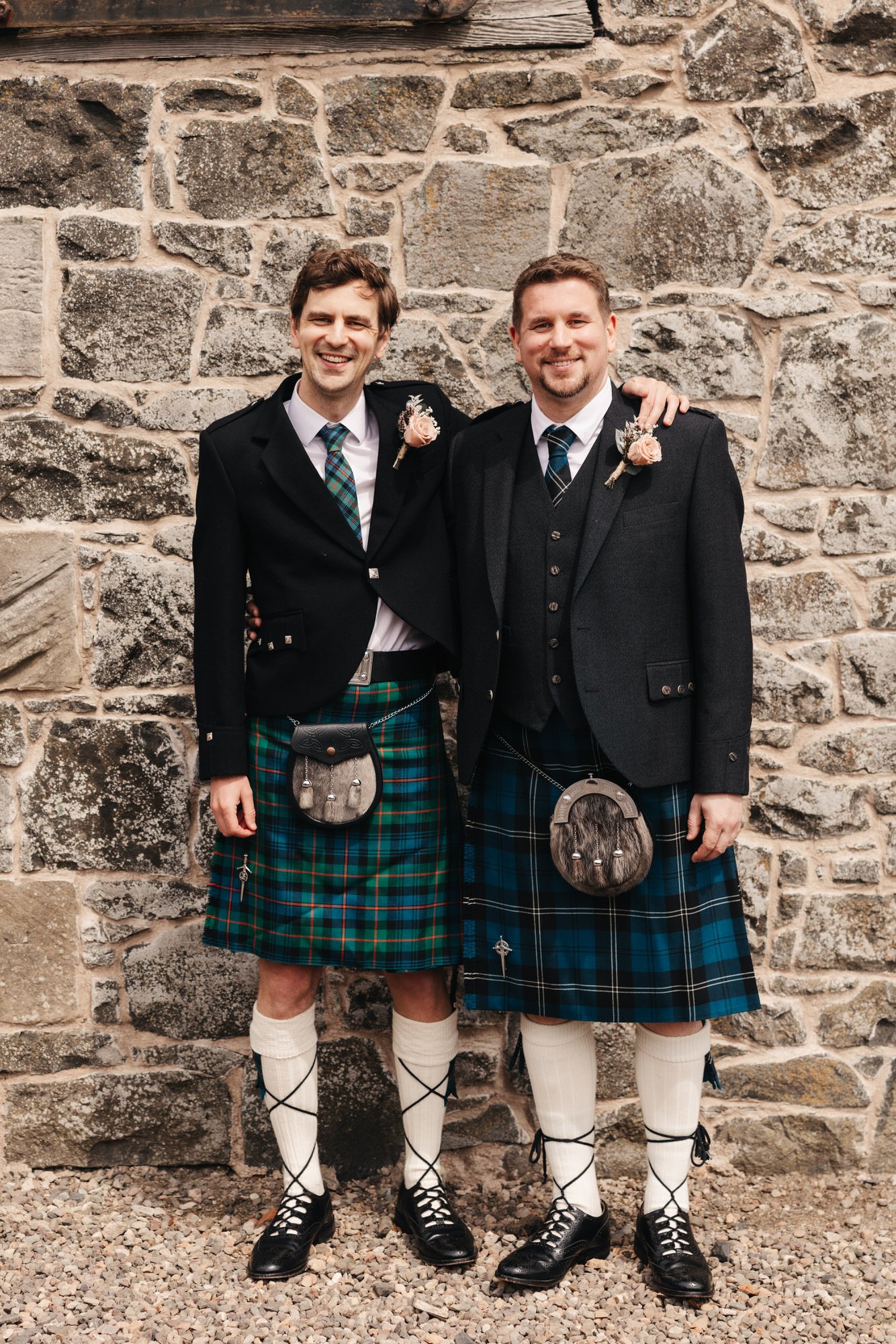 Alex and his best man in kilts outside a stone barn