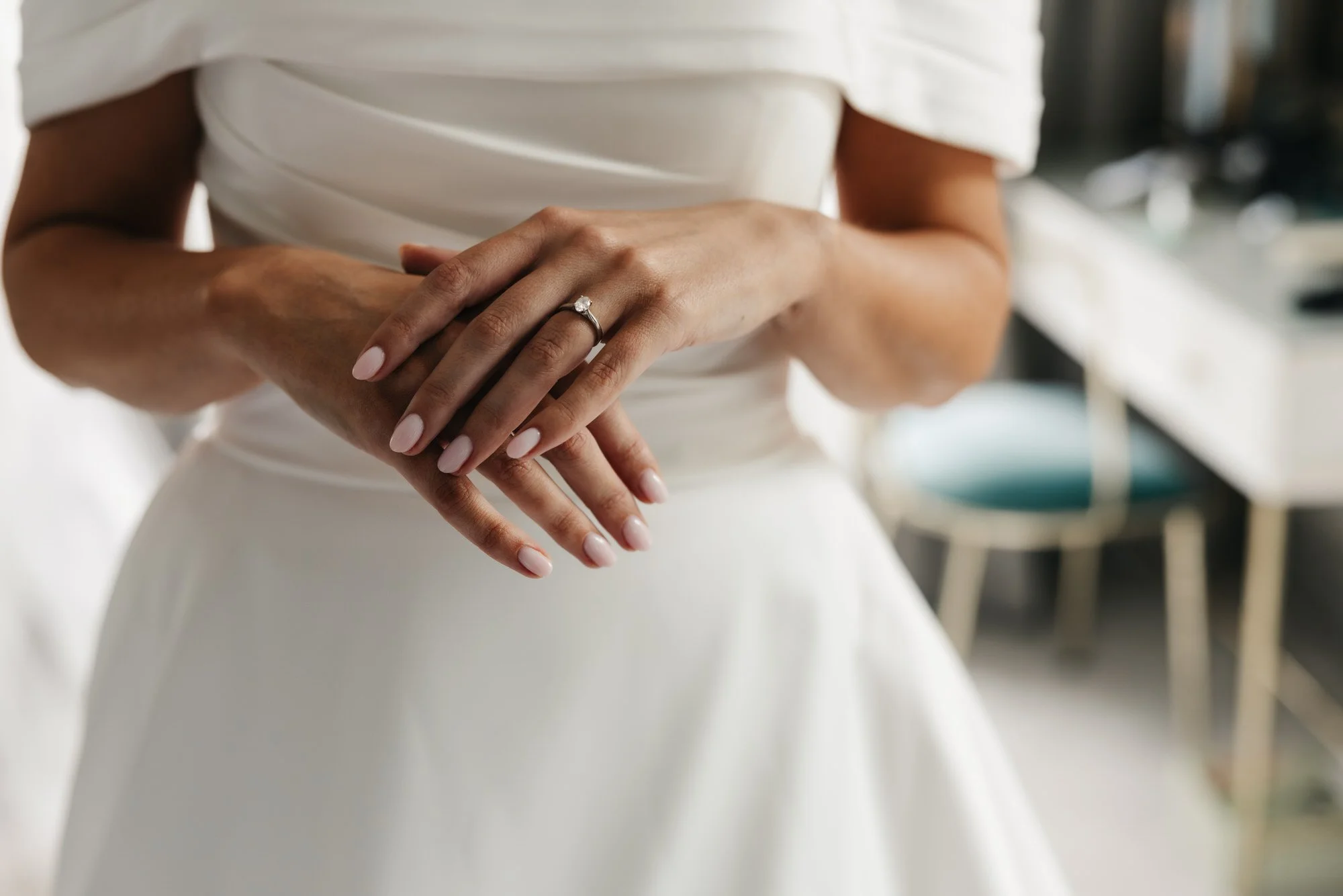 Claire’s hands resting on her white wedding dress
