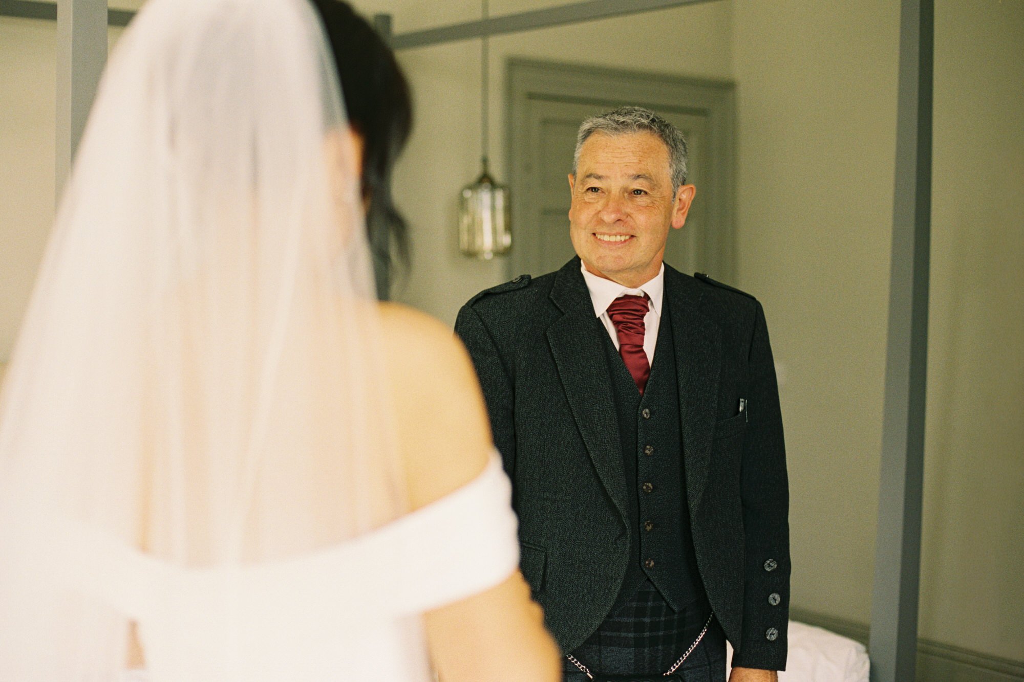 Wedding guest smiling as Claire shows her dress