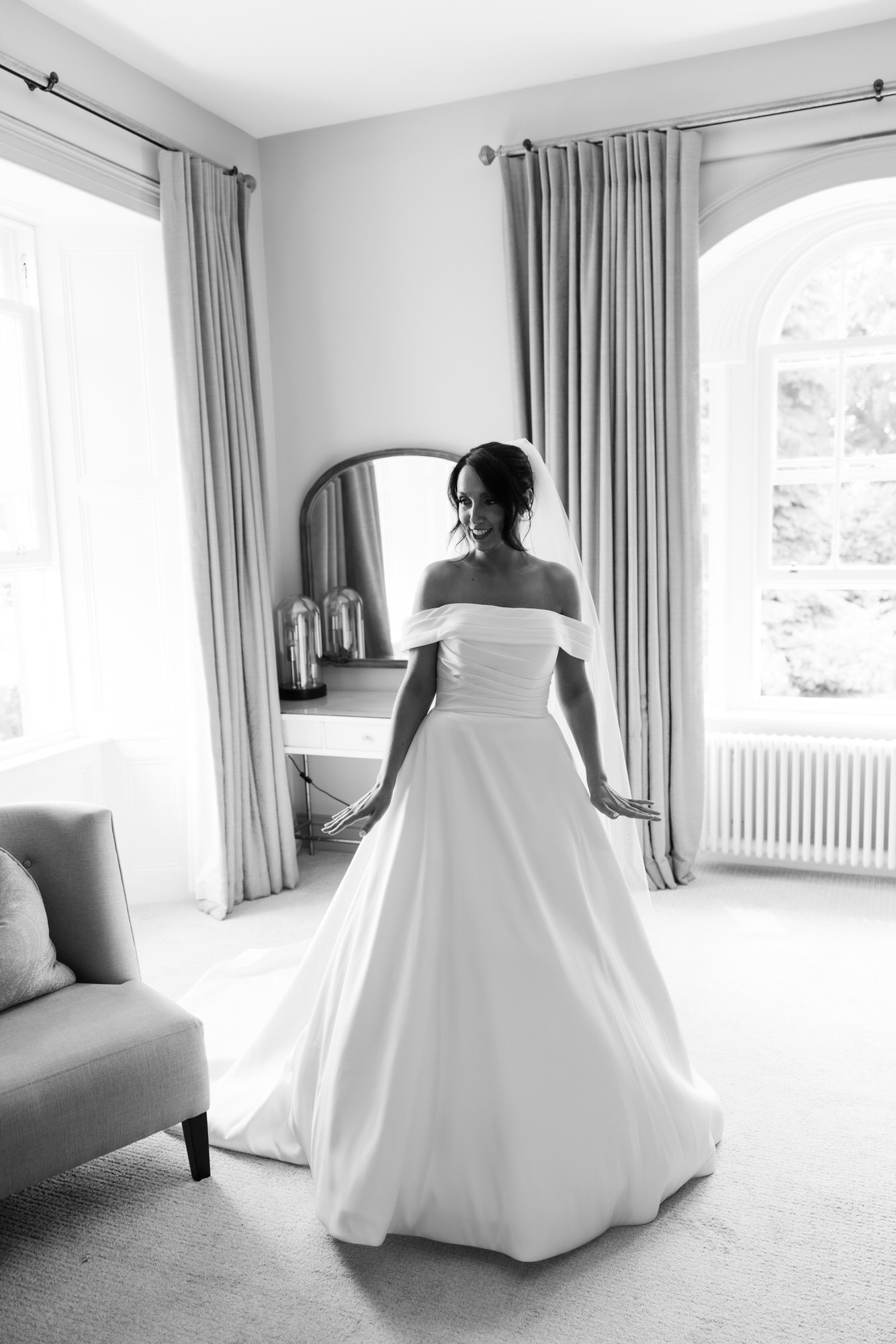 Black and white portrait of Claire standing by the window