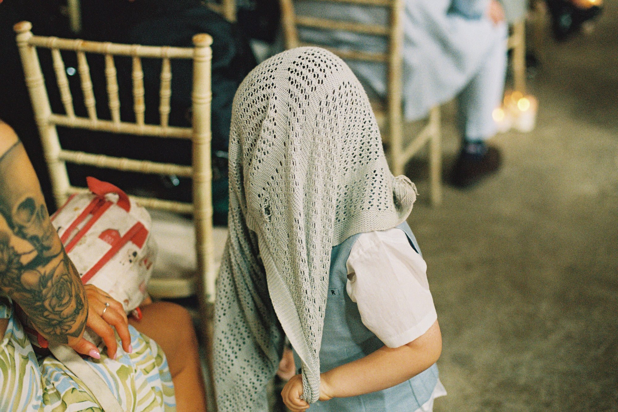 Young guest wearing a sunhat during the wedding ceremony