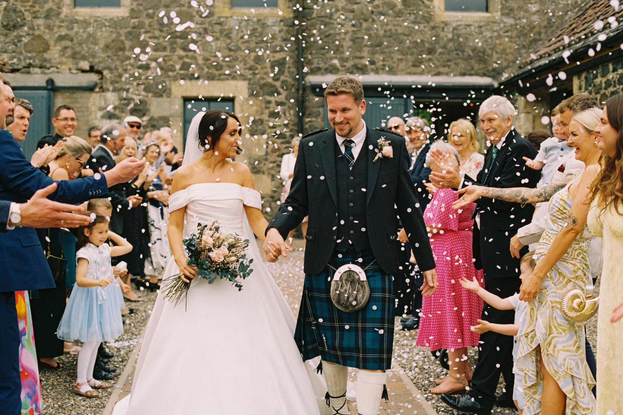 Courtyard confetti around Claire and Alex at Pratis Barns