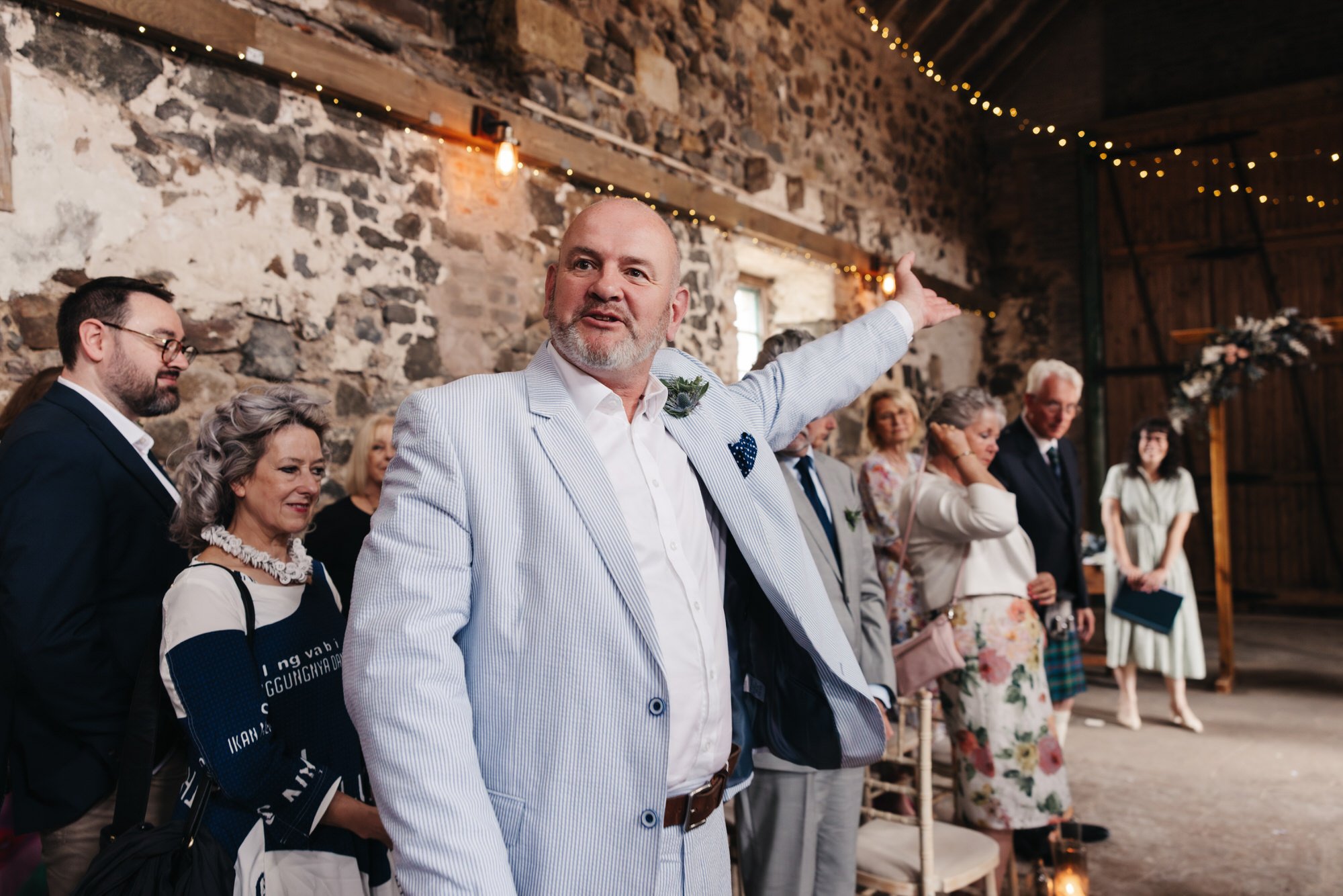 Wedding guest throwing confetti outside the ceremony barn