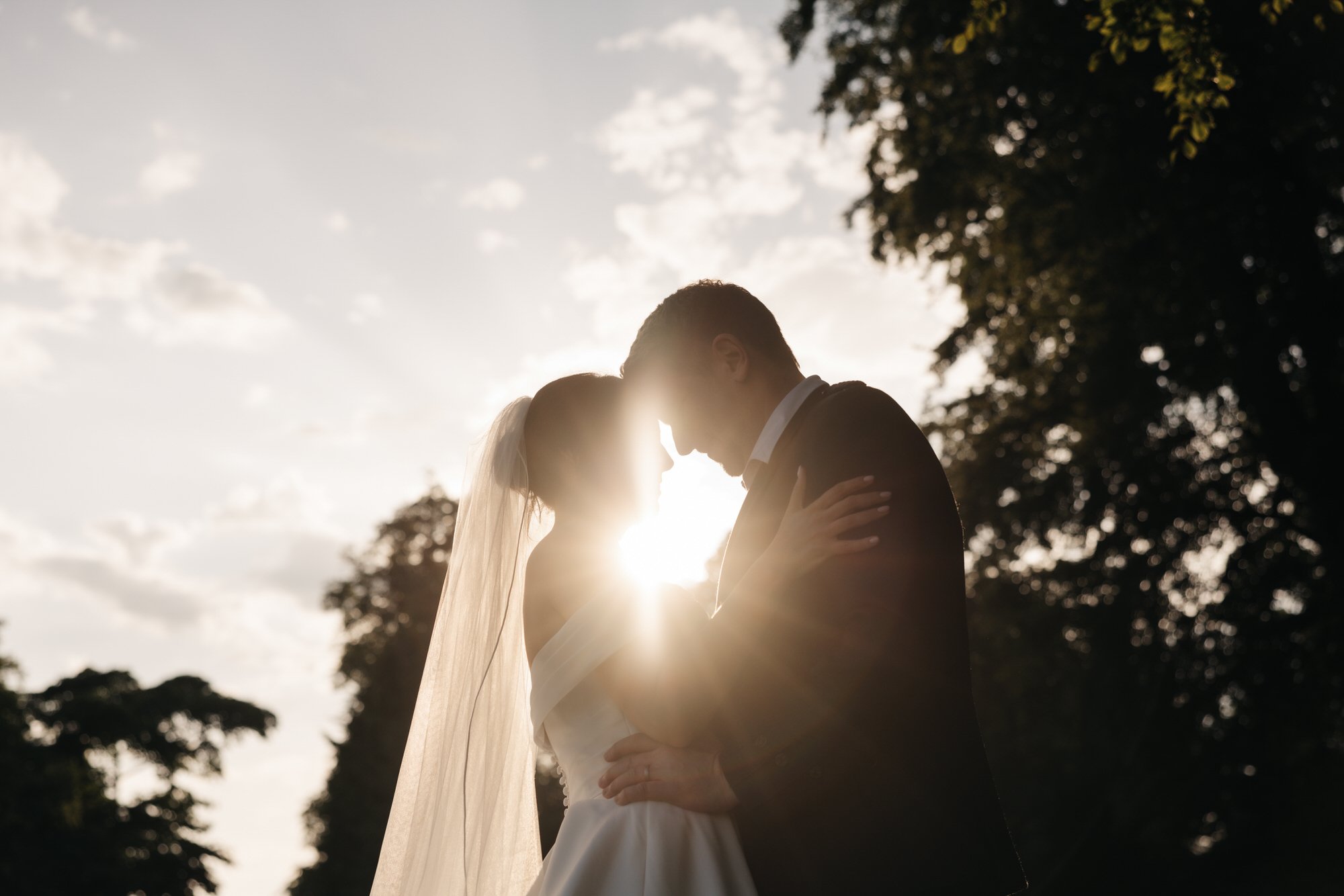 Sunlight shining between Claire and Alex as they kiss