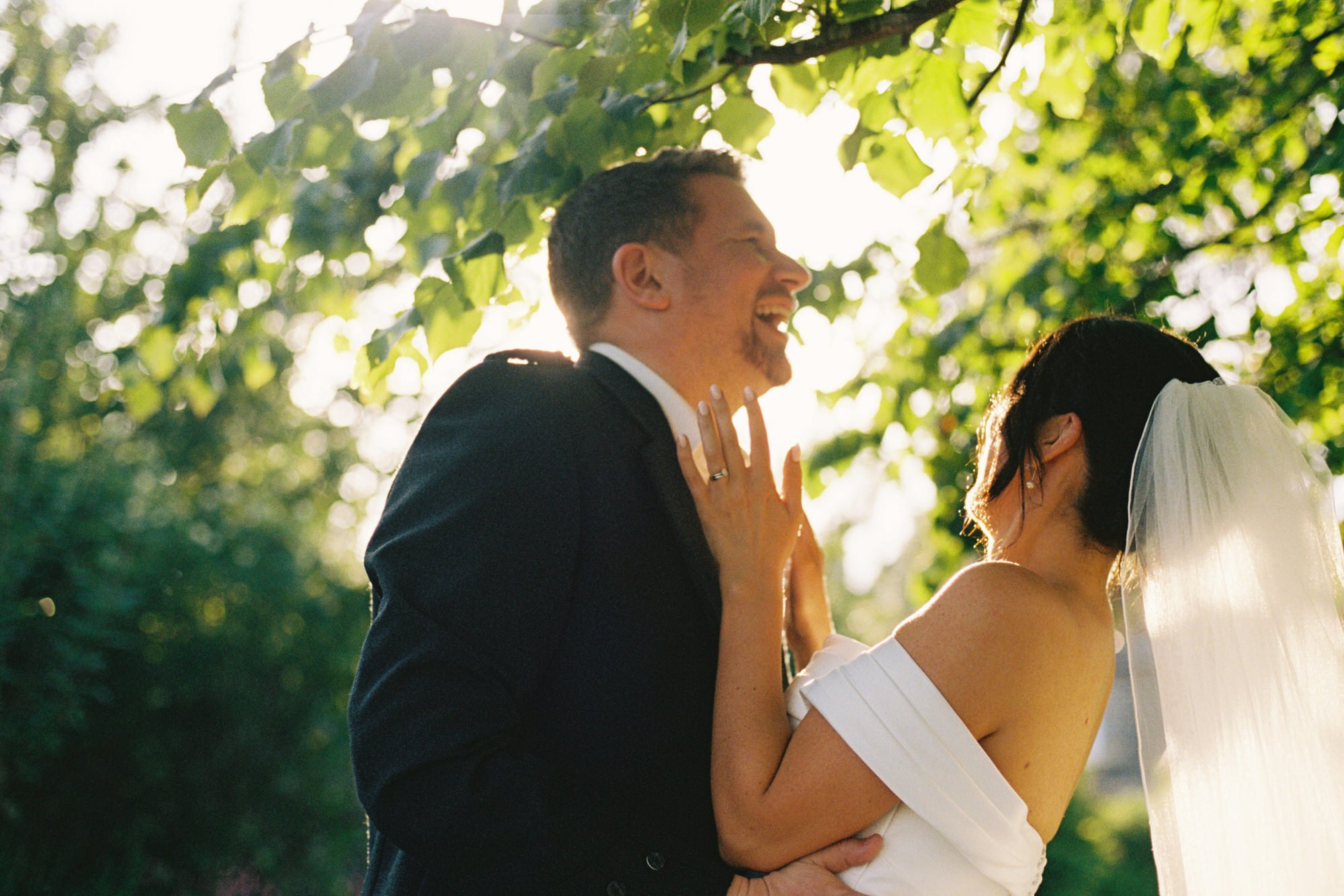 Claire smiling up at Alex during their wedding portraits
