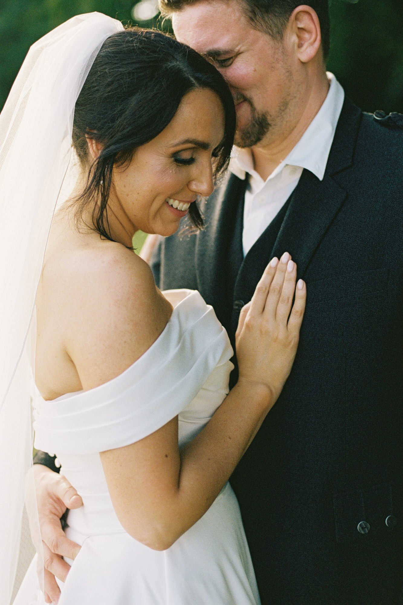 Close portrait of Claire and Alex embracing outdoors