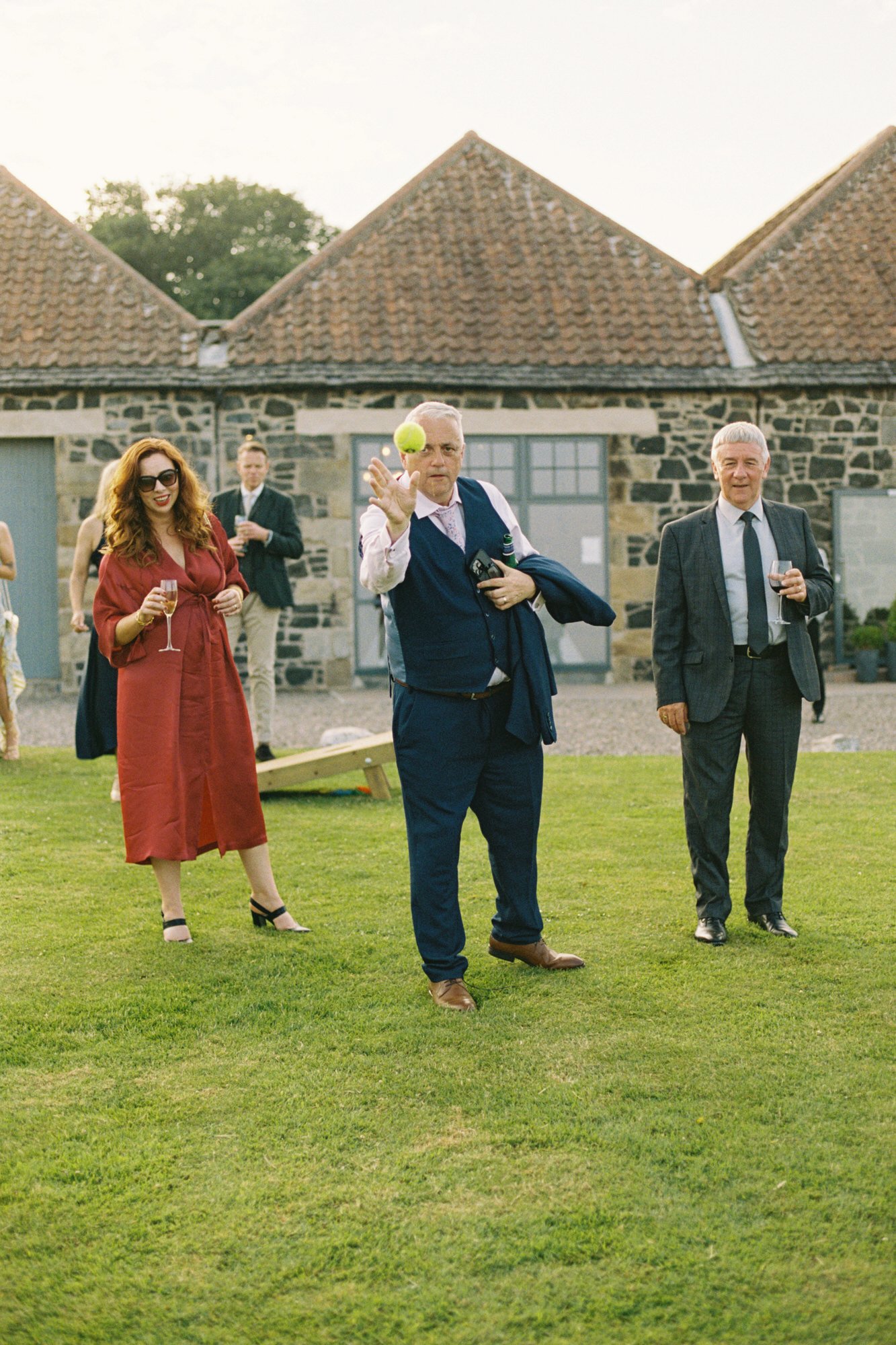 Guests enjoying drinks on the lawn outside the barns