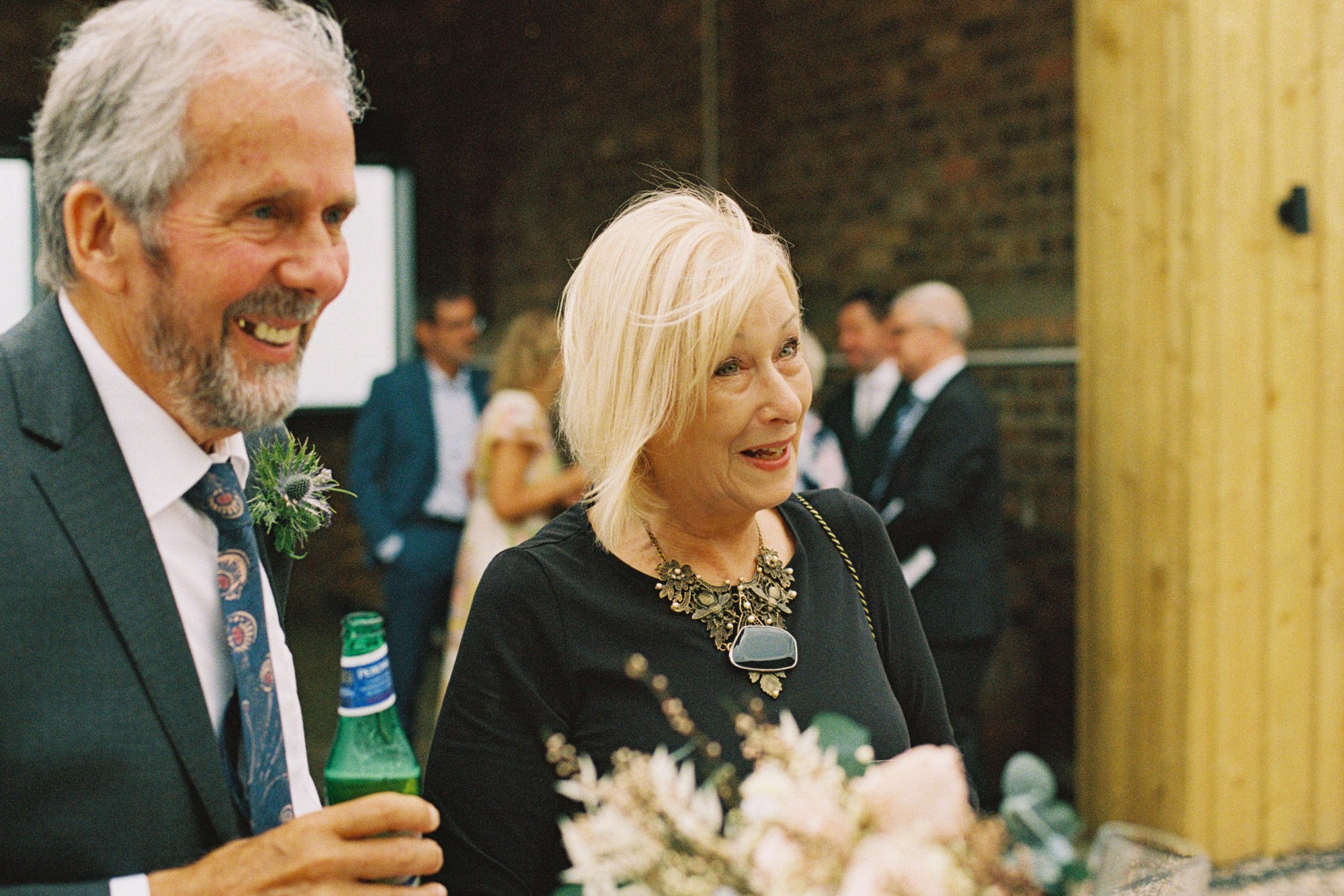 Wedding guests smiling outside the reception barn