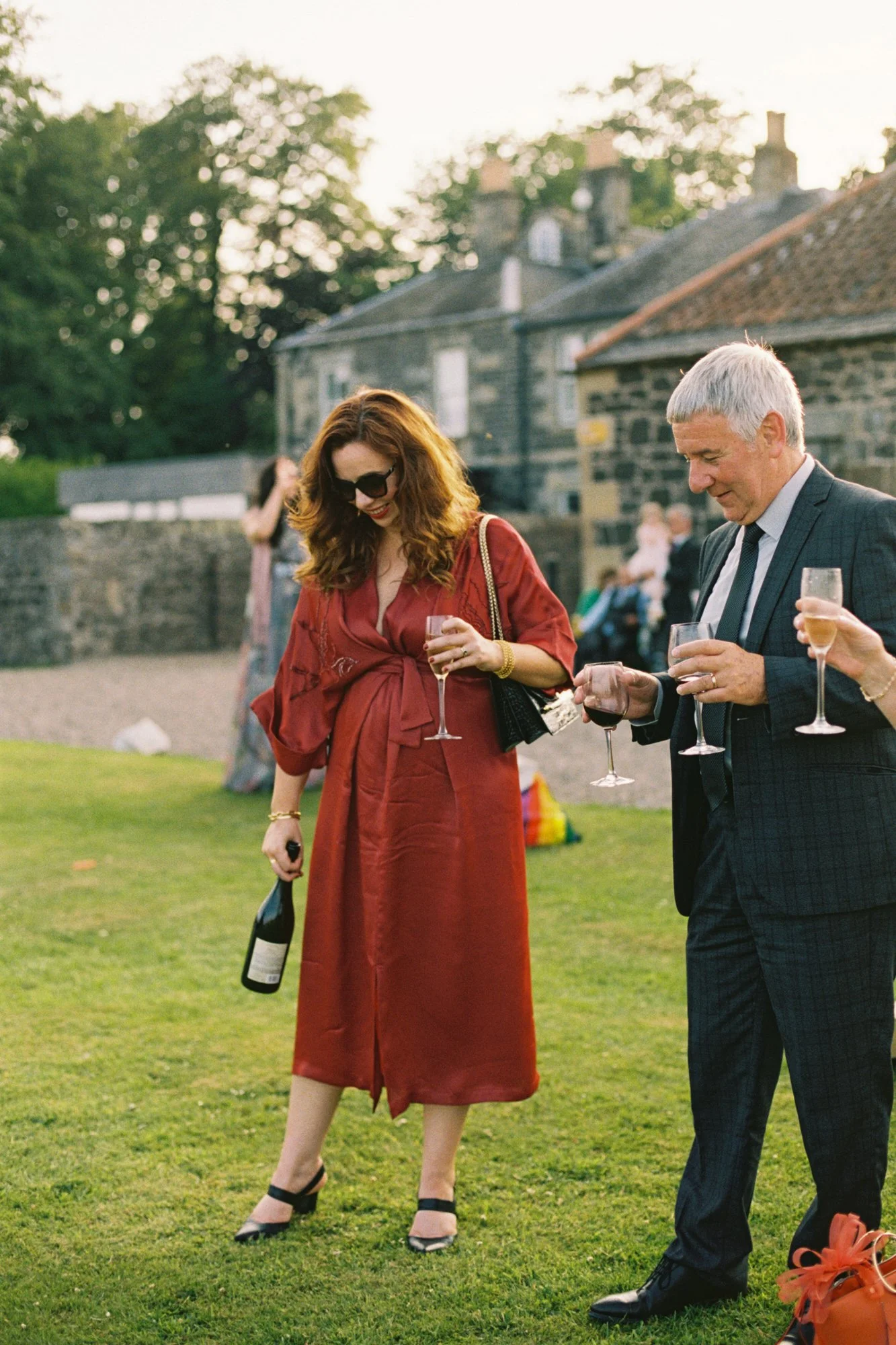 Two guests chatting with drinks in the late sunshine