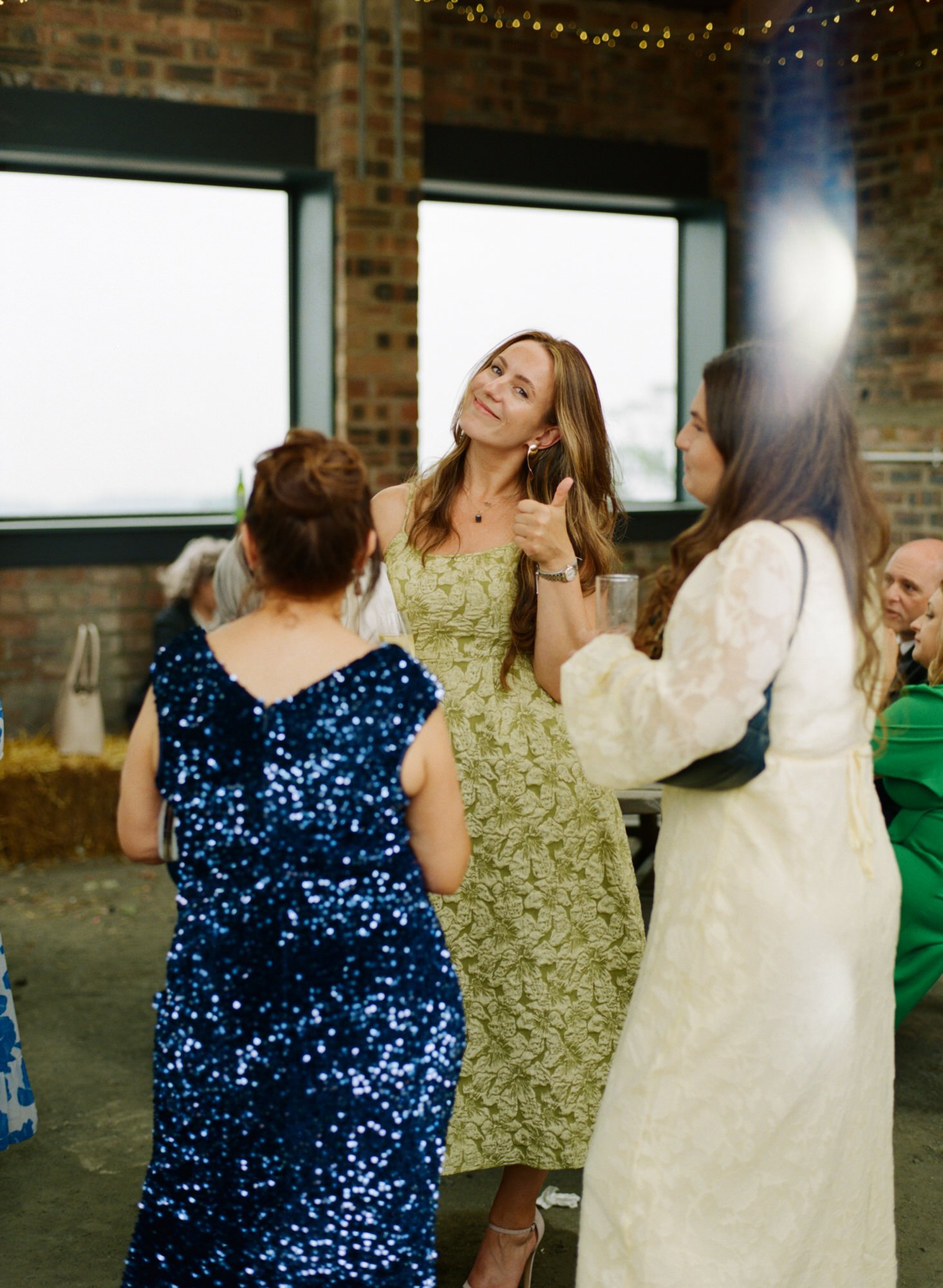 Guests gathered with drinks inside the reception barn