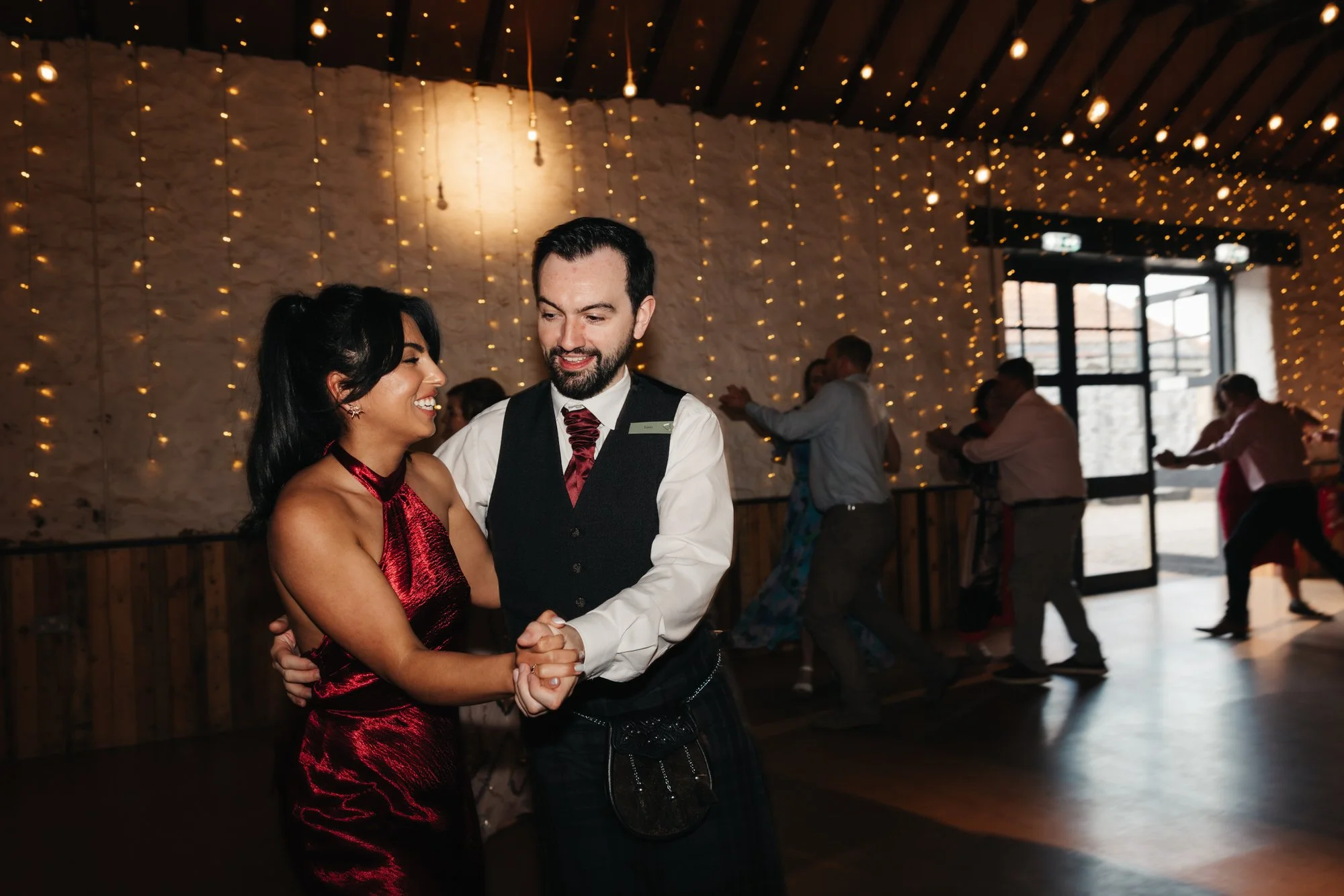 Claire and Alex dancing beneath the barn lights