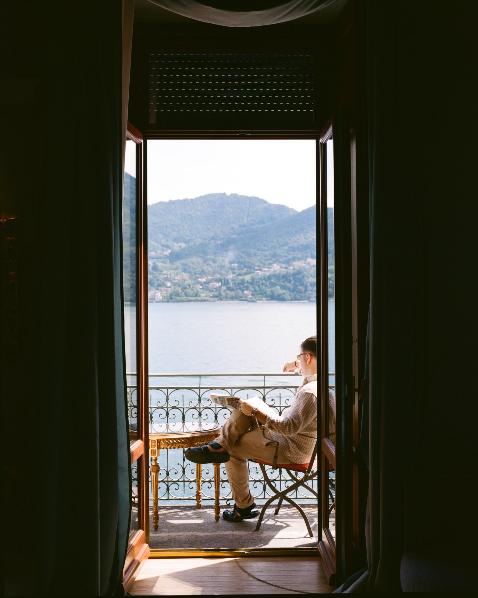 The open balcony doors framing Velia and Lake Como