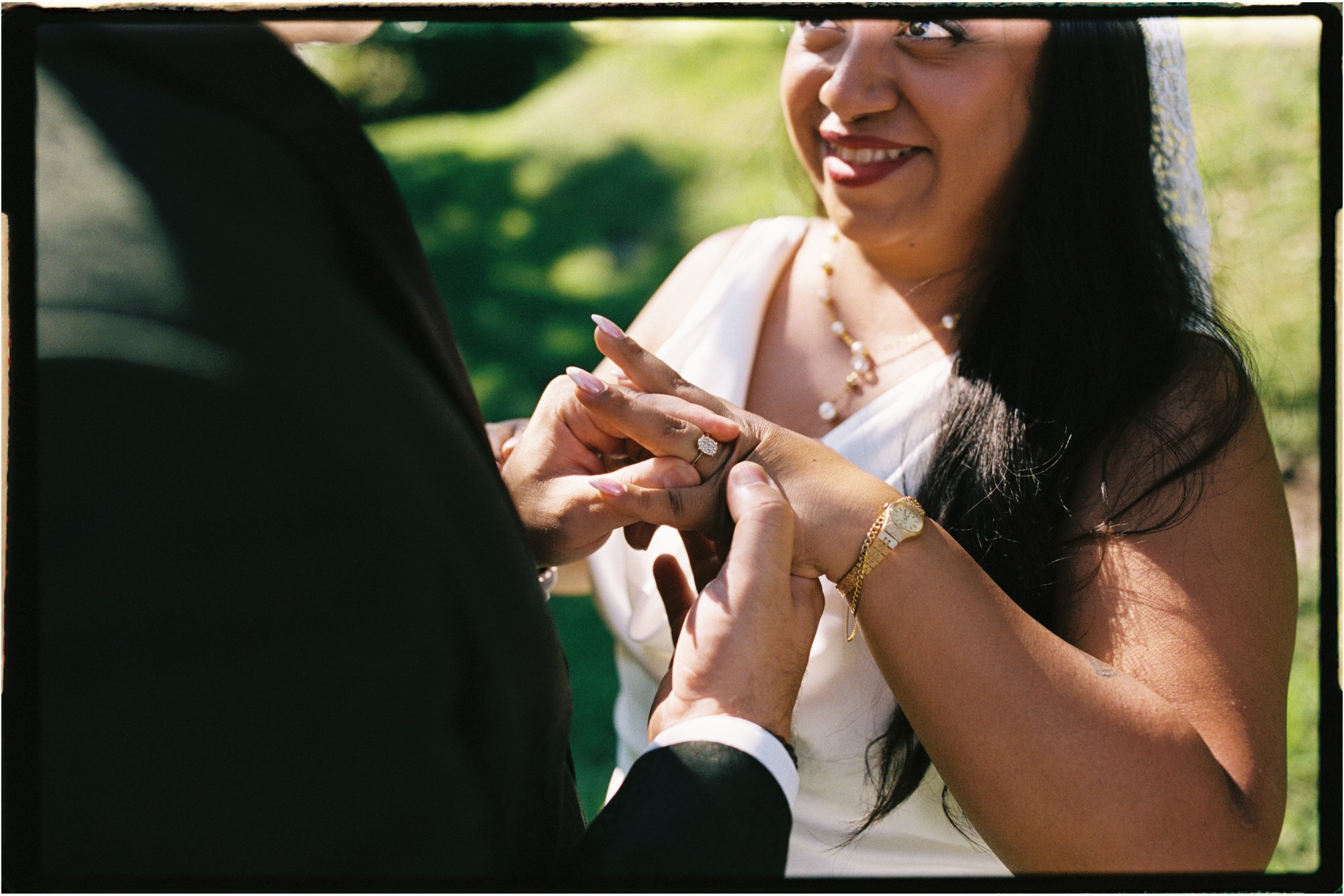 Velia smiling as Dan places the ring on her finger