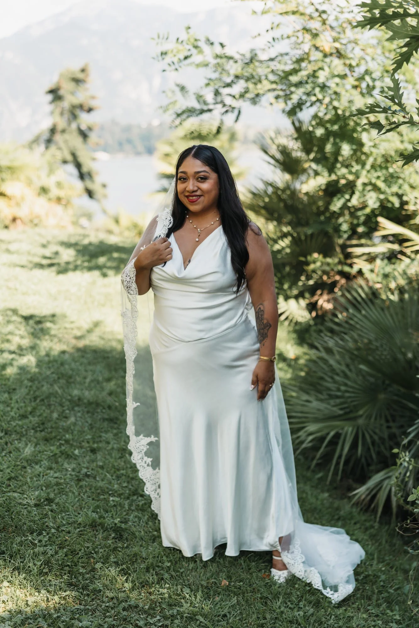 Velia standing in her wedding dress among the trees