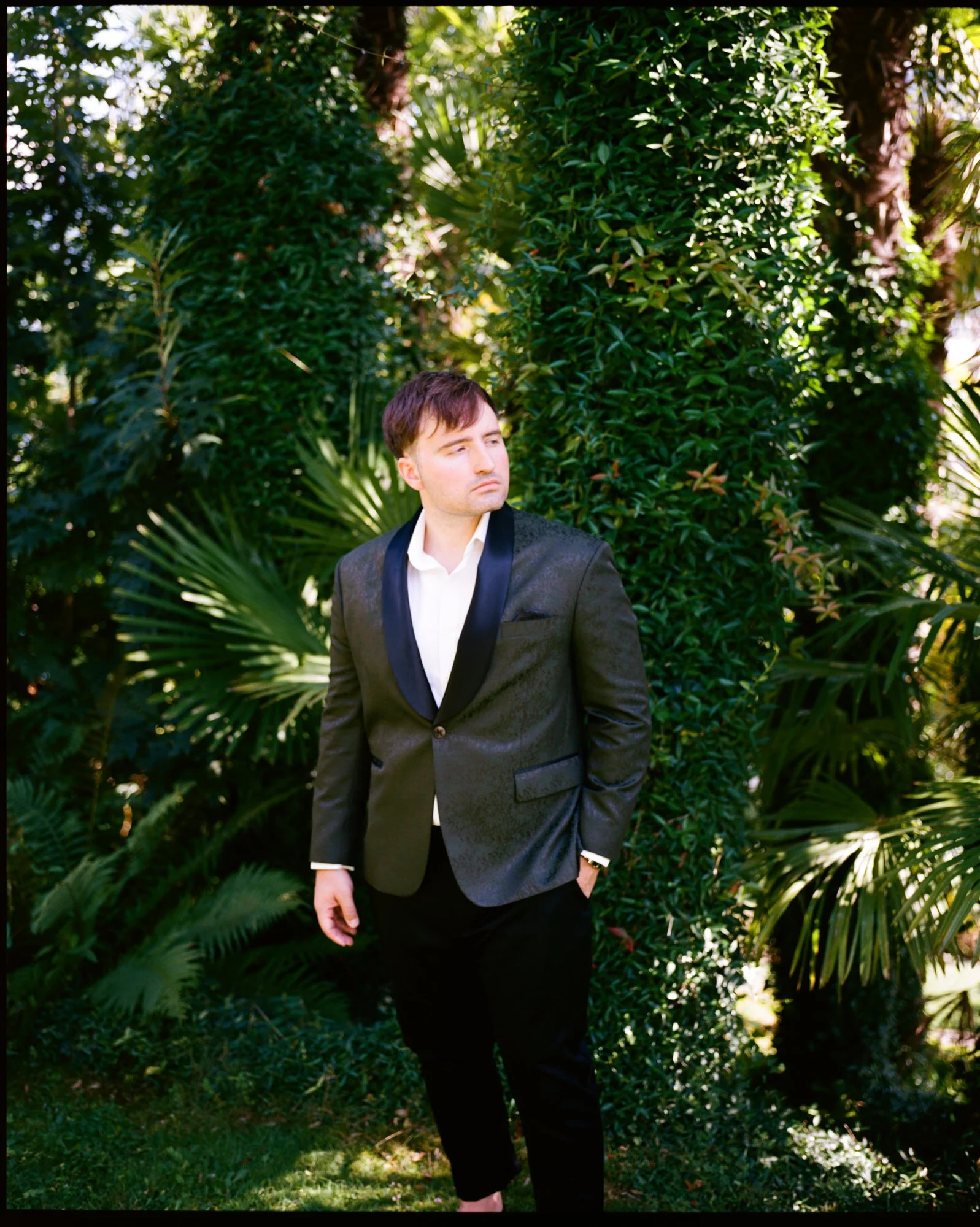 Dan beneath palm leaves in the hotel gardens
