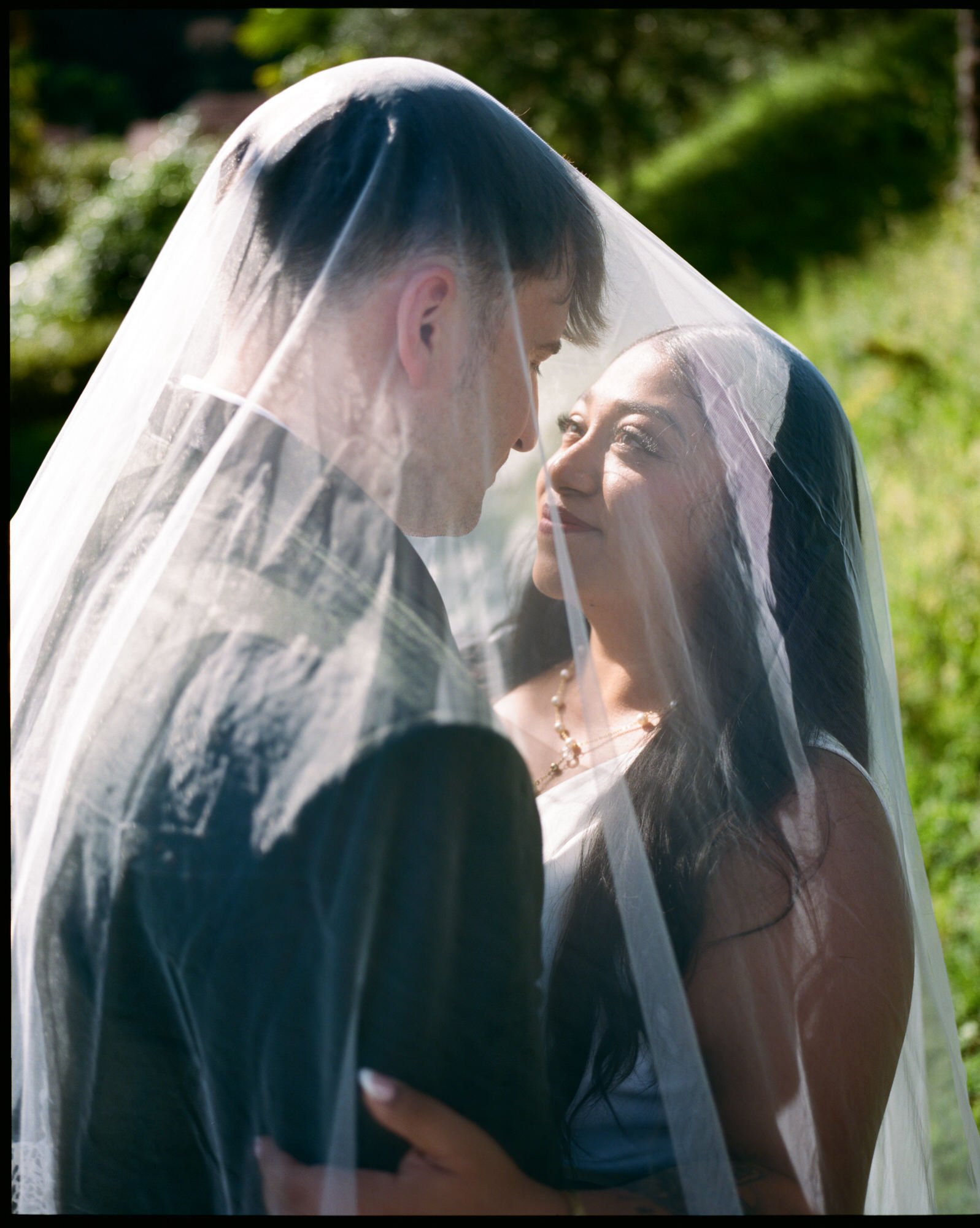 The couple kissing beneath Velia’s veil