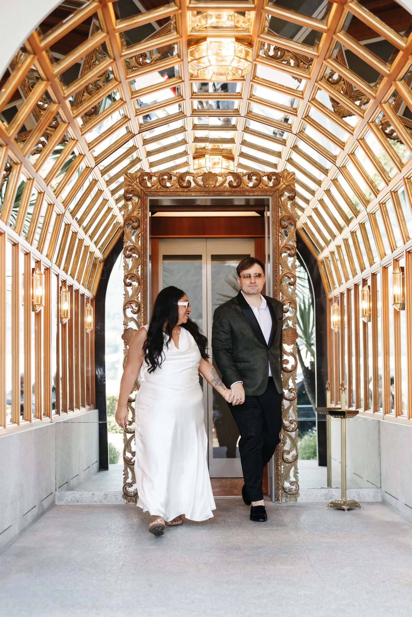 The couple walking through the hotel’s light-filled interior