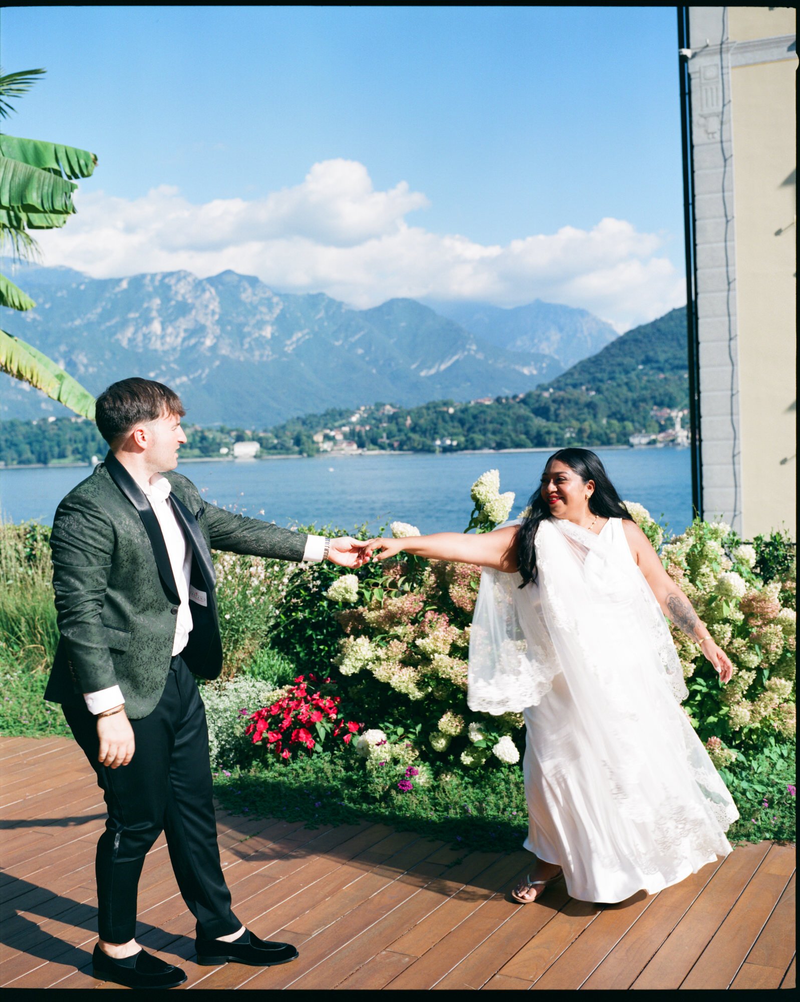 Velia and Dan holding hands on the lakeside terrace