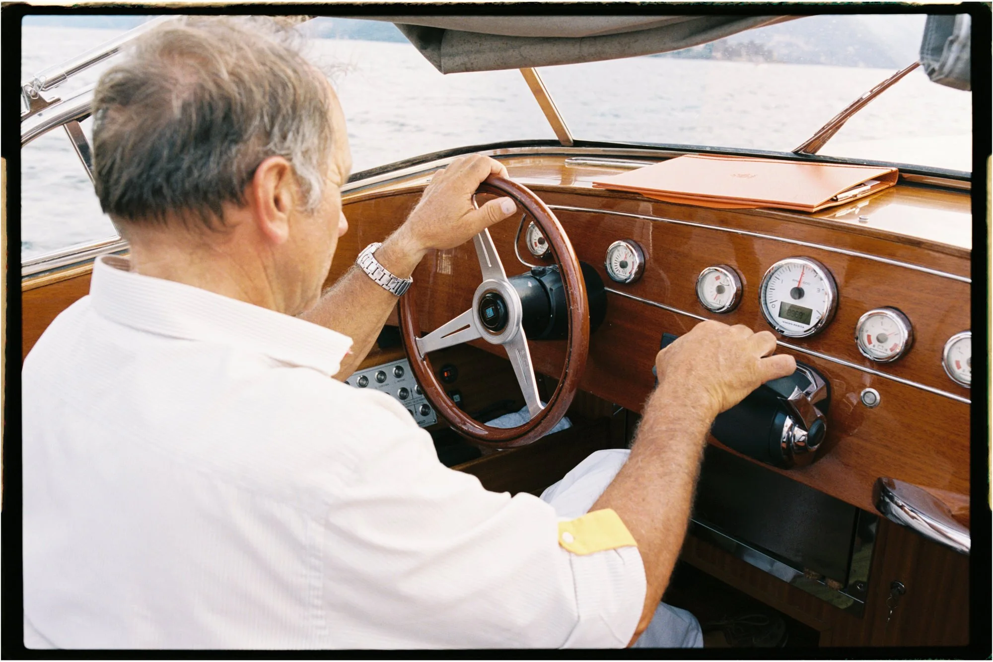 The captain steering the boat across Lake Como