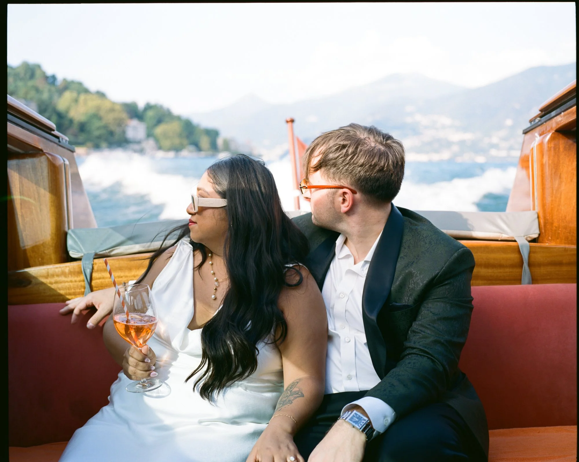 The couple looking out from the boat’s orange seats