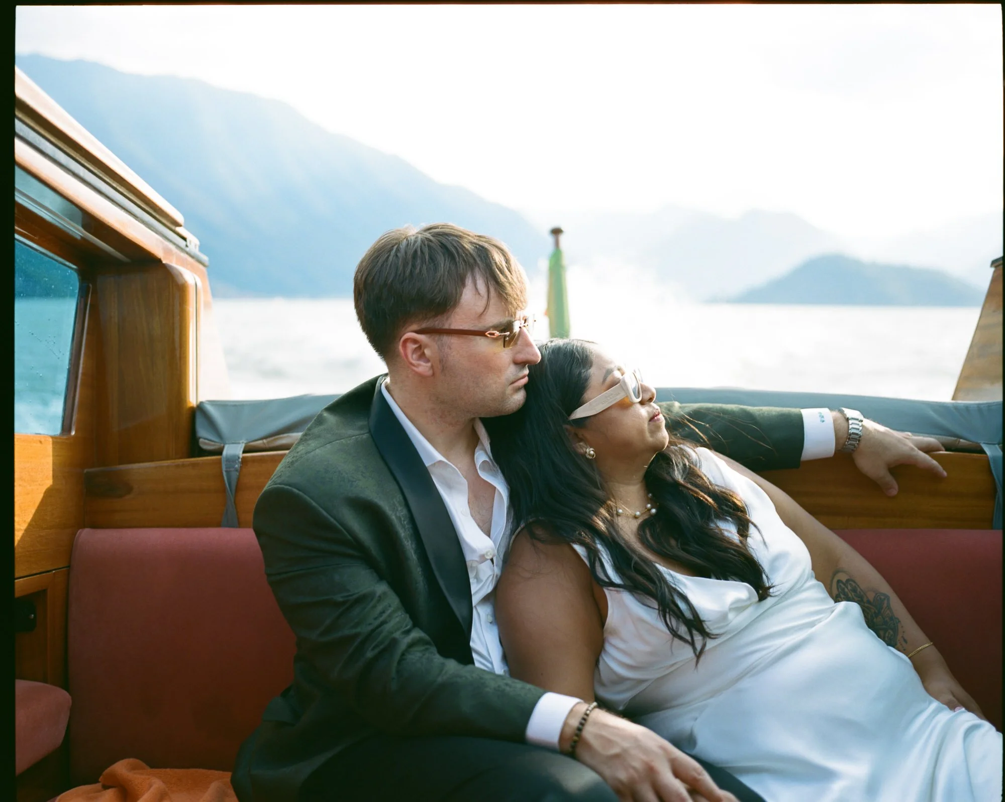 The couple sharing a kiss aboard the wooden boat