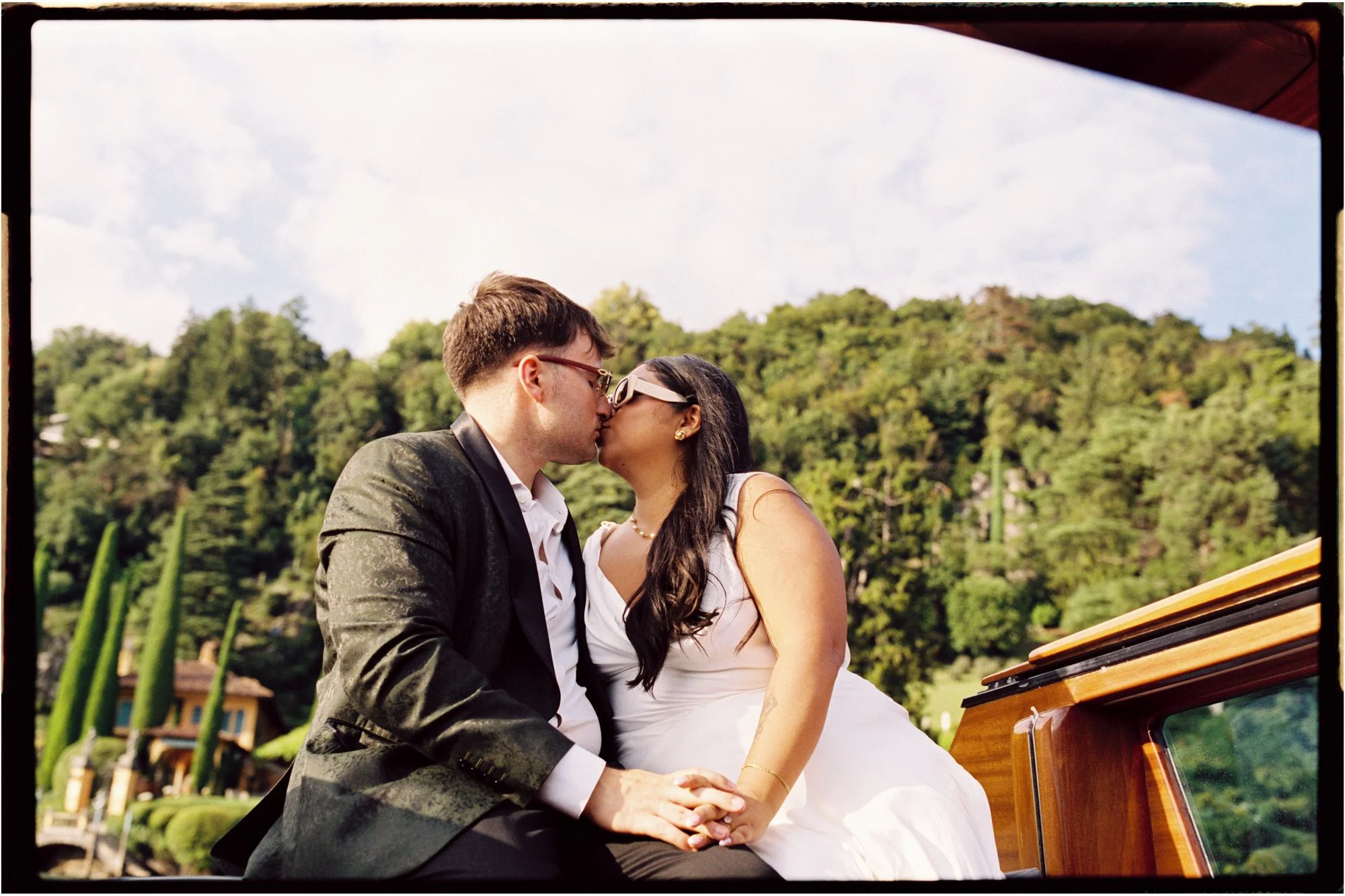 Velia and Dan kissing with the shoreline behind