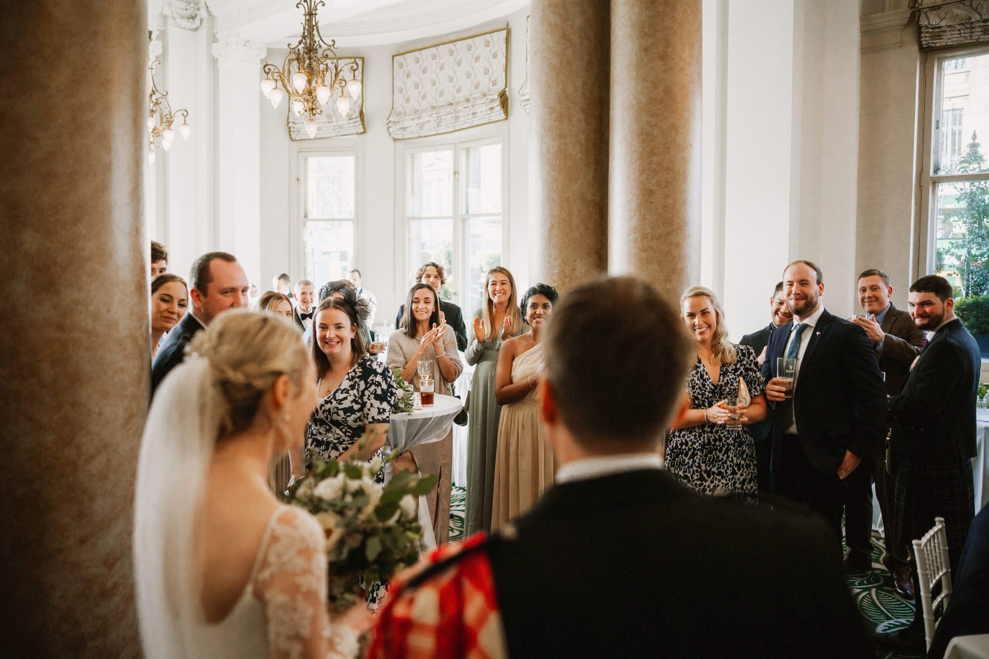bride and groom enter room to cheering and clapping guests