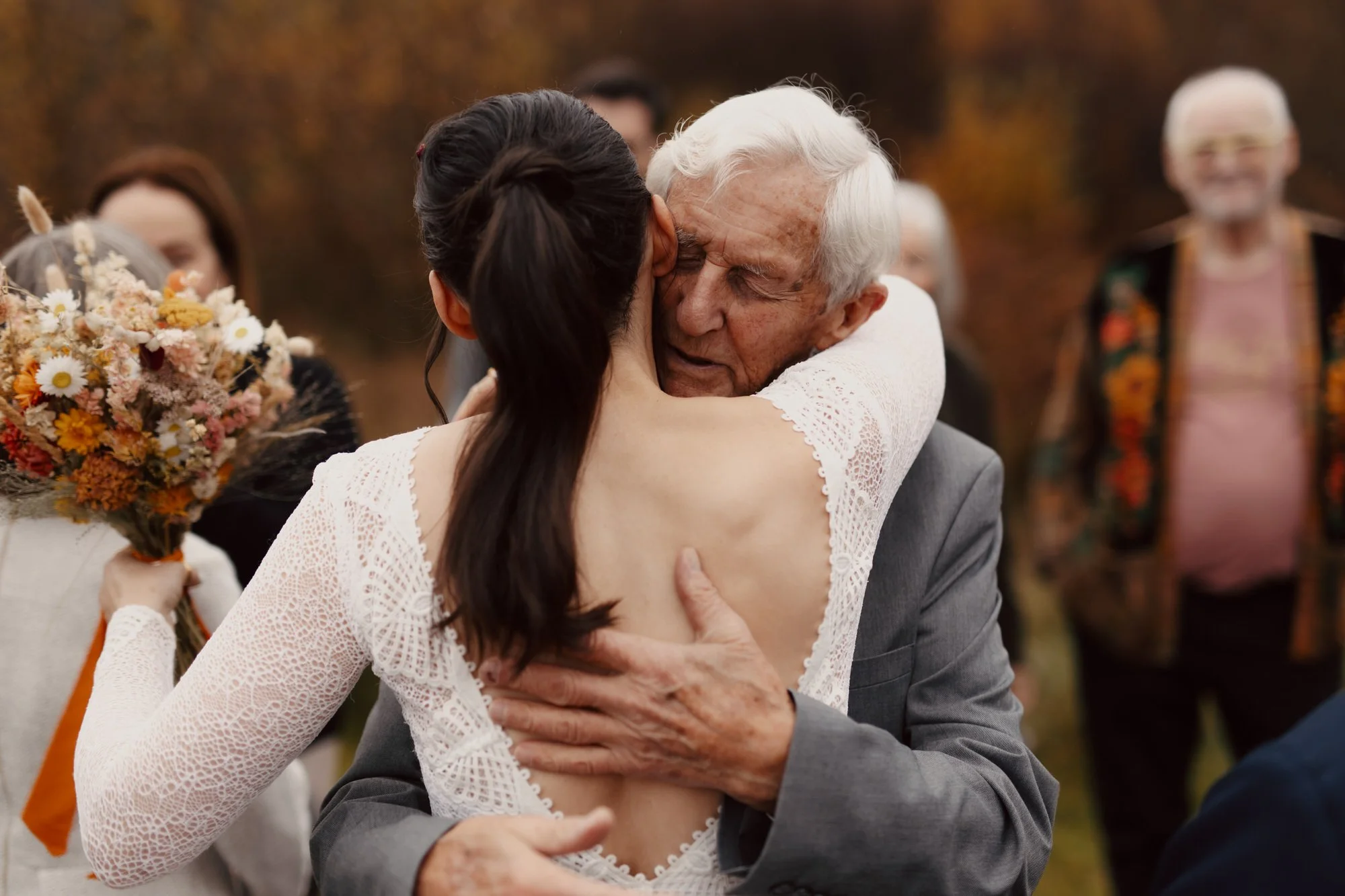 elderly relative hugs bride after ceremony 