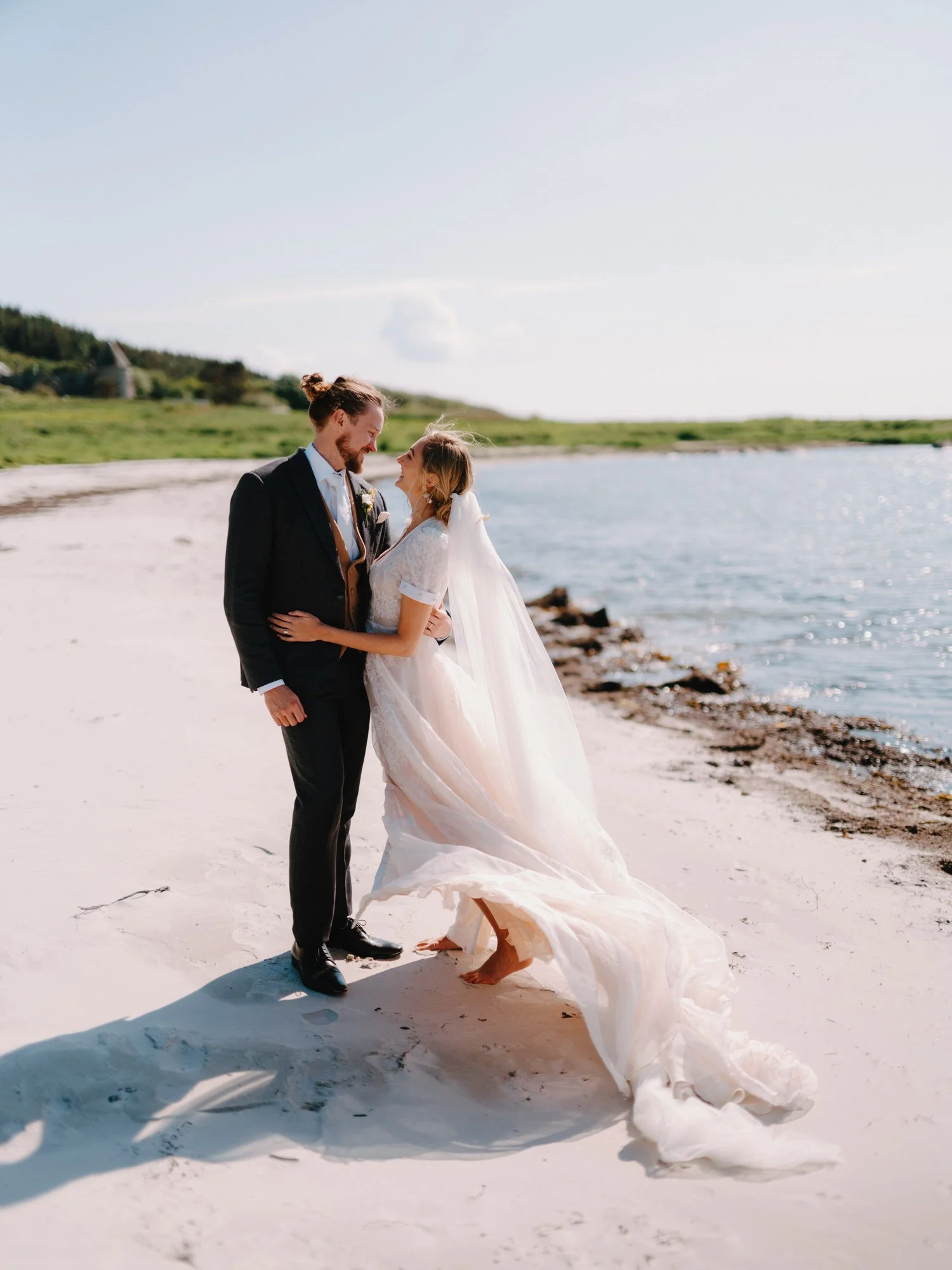 bright and groom portrait on white sand beach