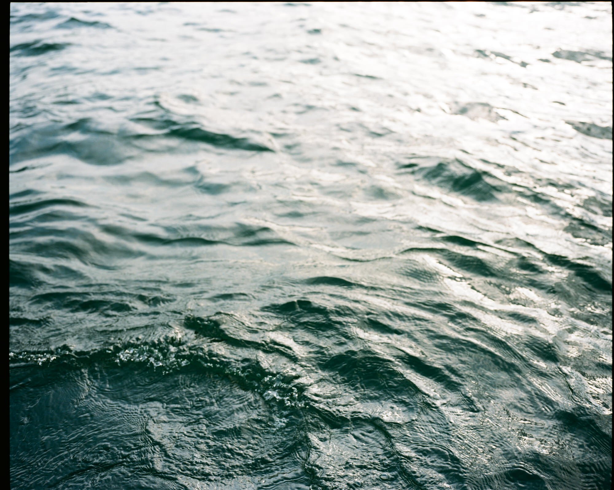 Ocean water with gentle waves reflecting sunlight. Photographed by Steven William Weir, Edinburgh Scotland.