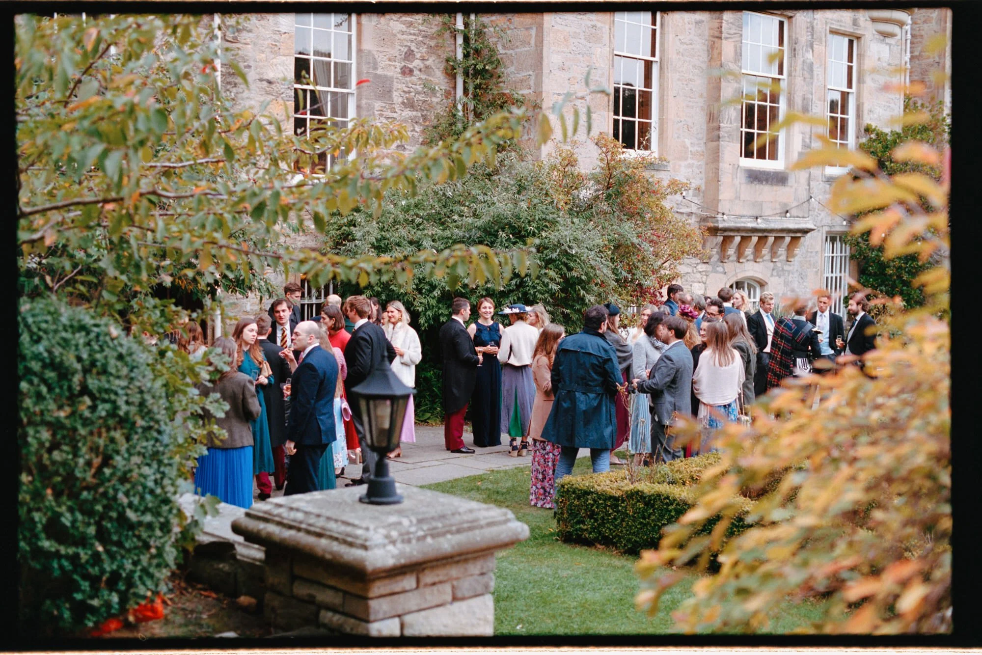 guests gather in garden after wedding ceremony 