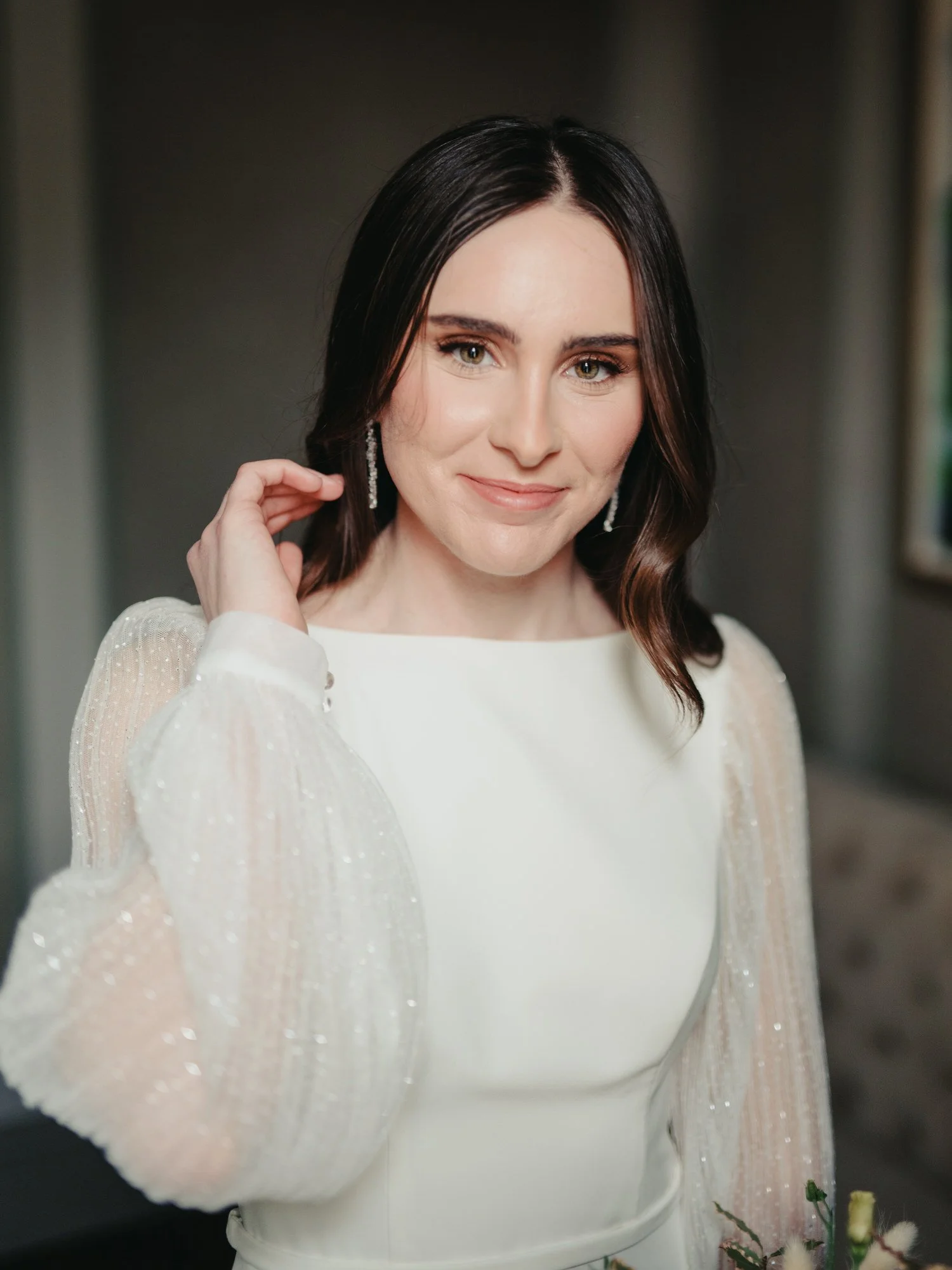 bride pushes hair back and looks at camera for a portrait