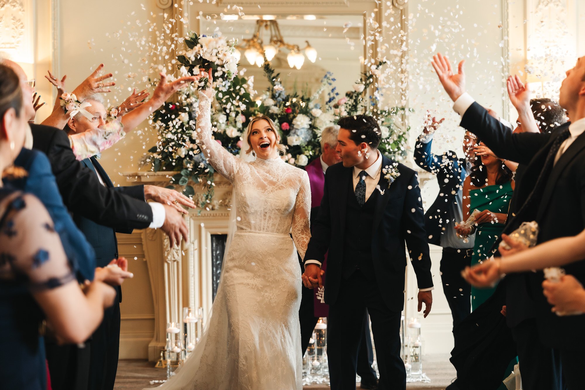 Newlyweds walking through confetti after their wedding ceremony