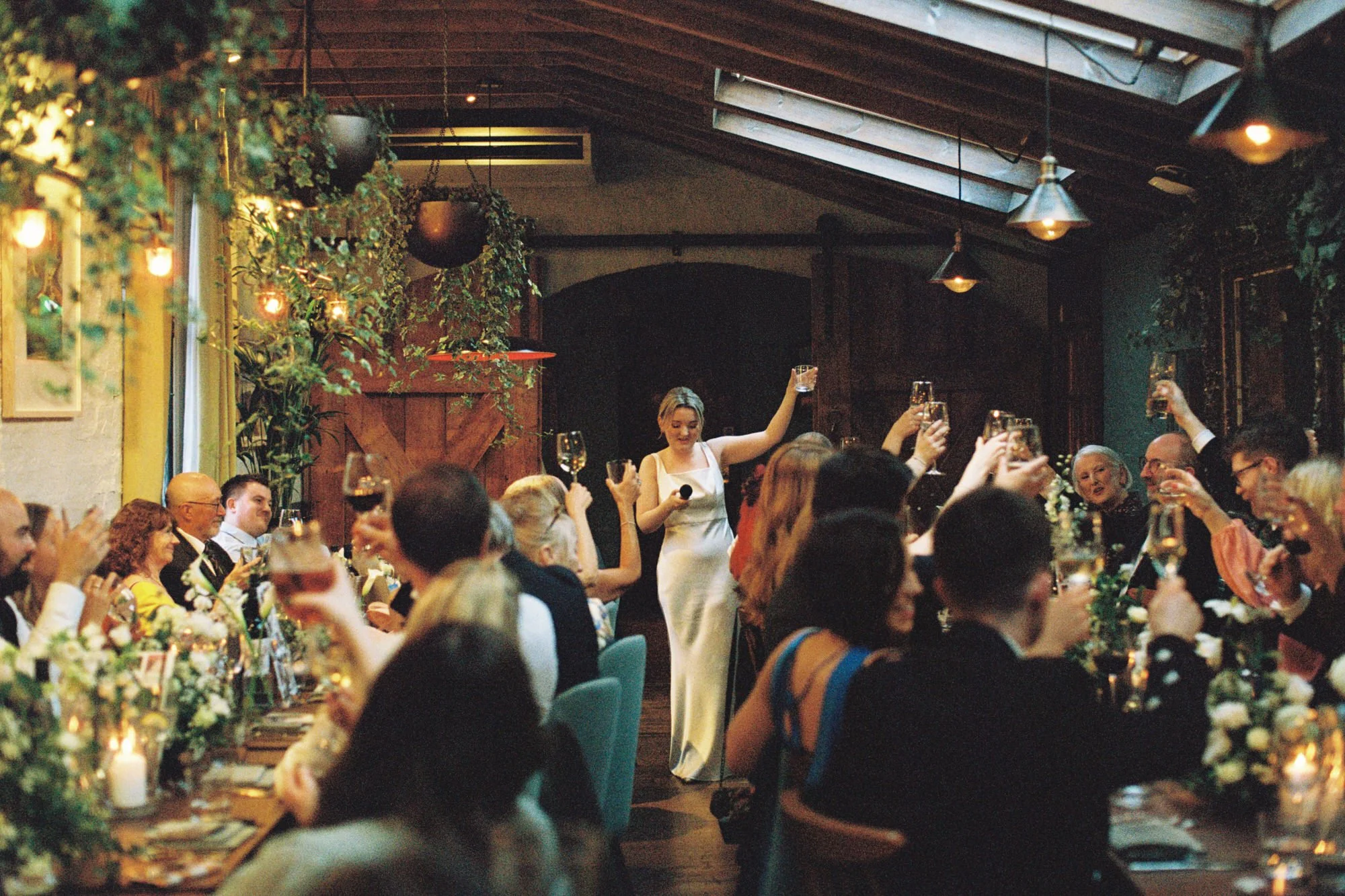 Wedding guests dancing beneath warm lights at the reception