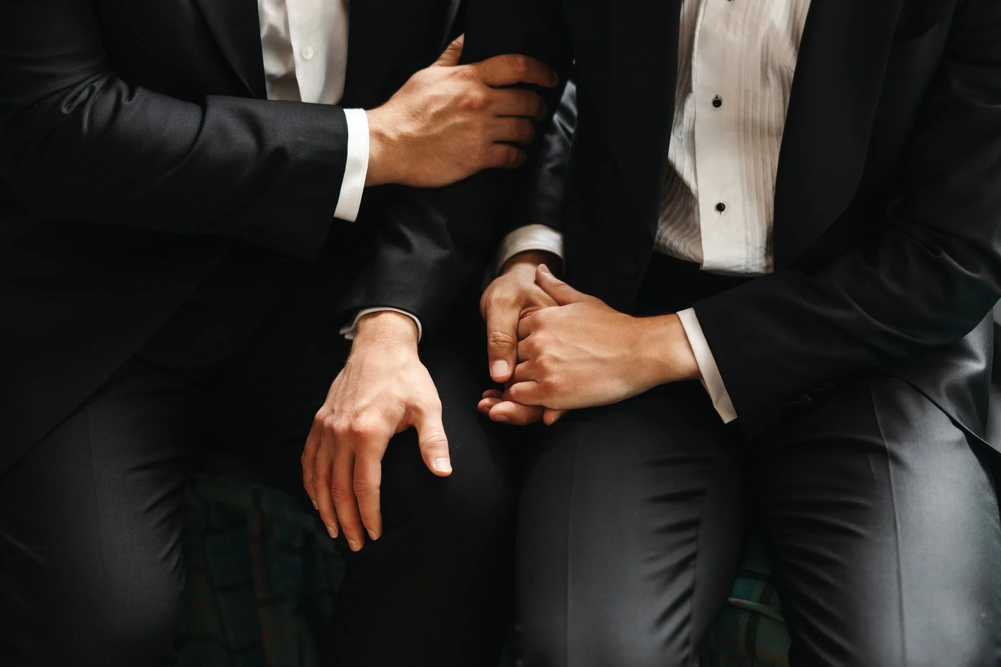 detail photograph of grooms holing hands