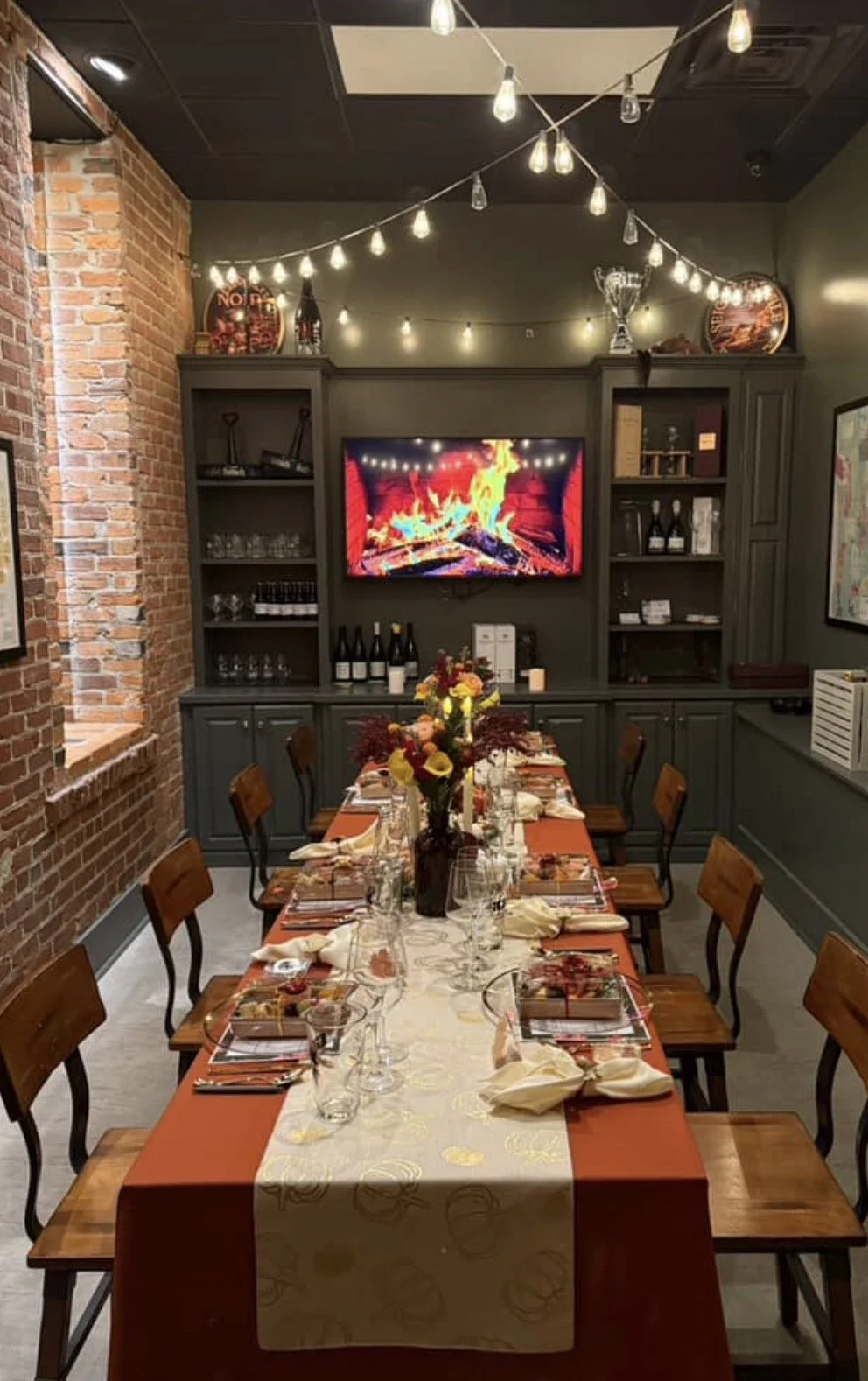 A professional view of the 12-seat private boardroom at the Greenville Beer Exchange. The room features a long, polished wooden table