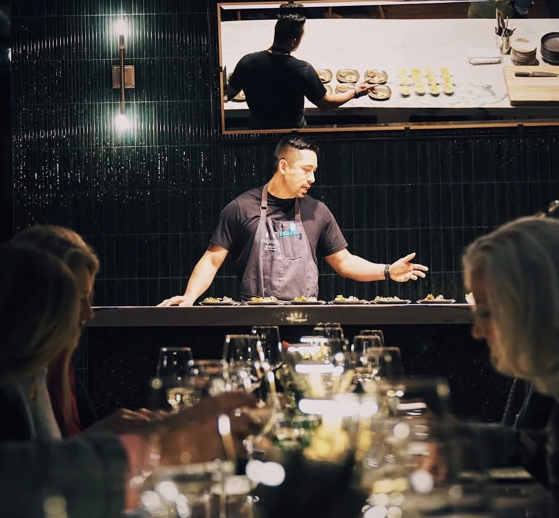 Chef Ryan Gomez presenting his culinary creations at the new Greenville concept, Hone. He is pictured mid-explanation at a beautifully set table