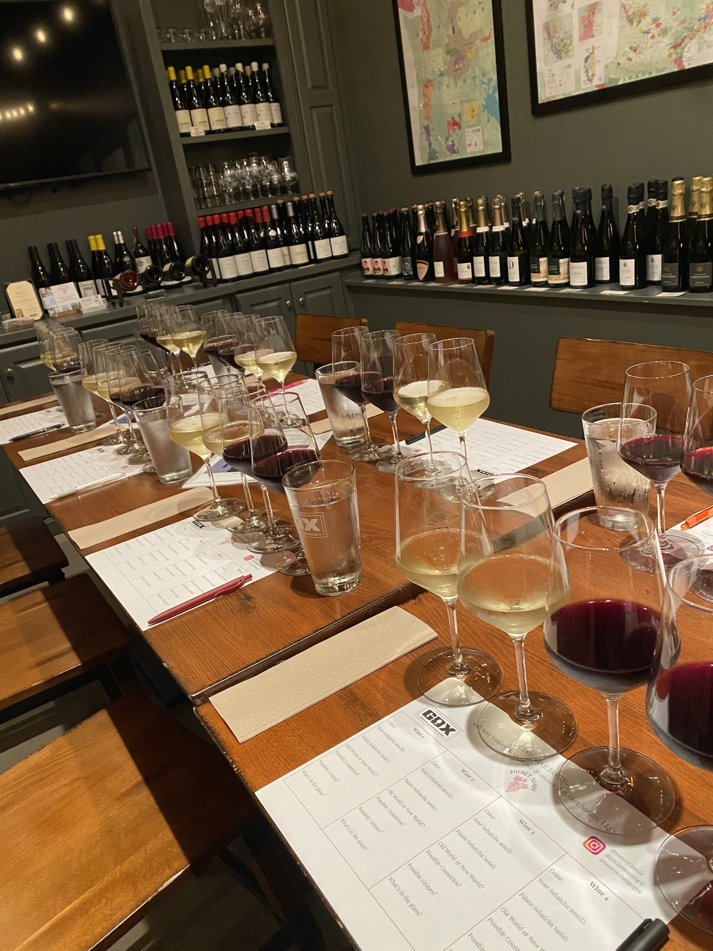 An empty boardroom table at Greenville Beer Exchange set for a private wine tasting. Each seat features a flight of four wines and tasting placemats.