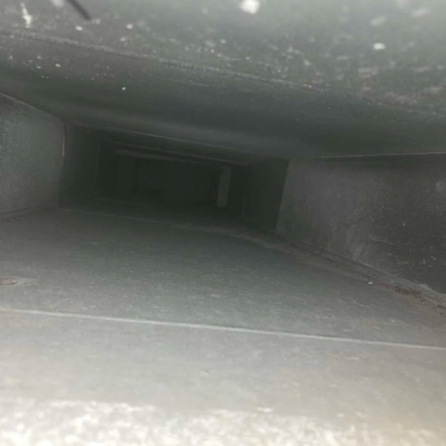 A dark, narrow, and deep square-shaped tunnel or vent with a slight perspective view.