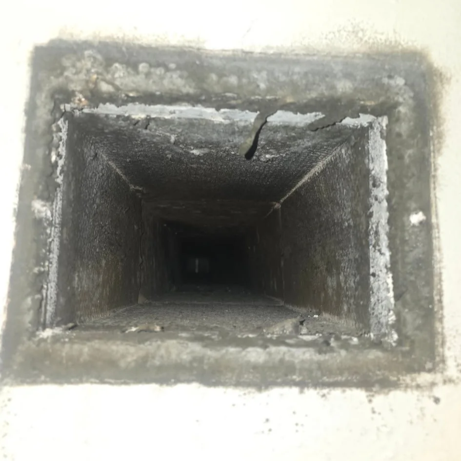 Close-up view inside a rectangular, dark duct or pipe.