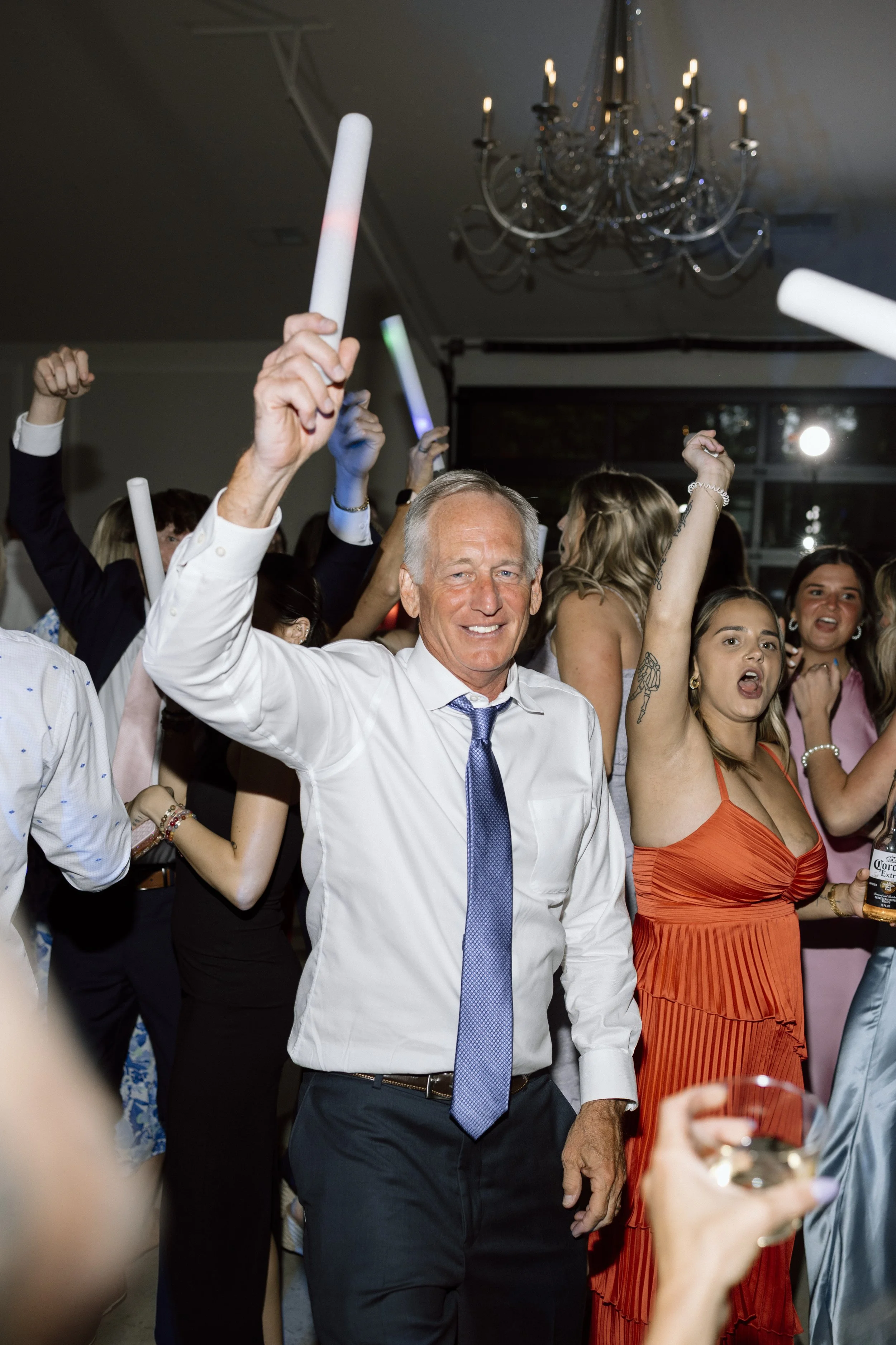 Man and woman celebrating at a party with glow sticks.