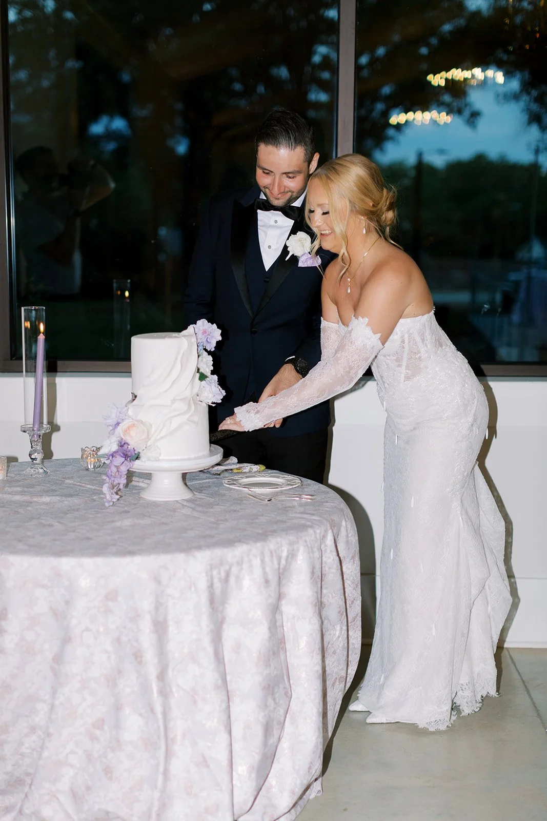 Bride and groom cutting a wedding cake together during their wedding reception.