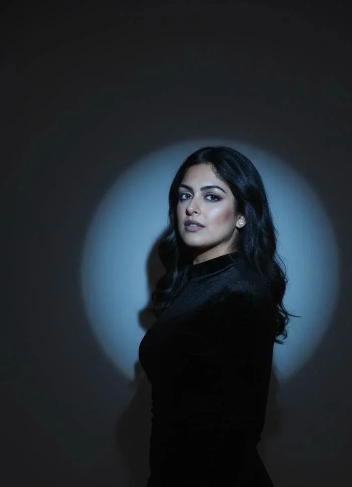 Cindy Kumar, CPA and financial strategist, in a fitted black top against a dark dramatic backdrop with a circular spotlight — editorial brand portrait, It's Cindy Kumar