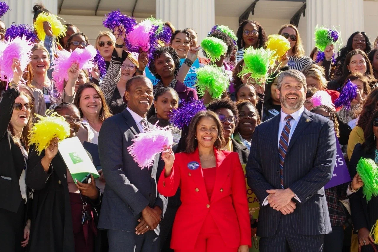 Melanie Bridgeforth celebrating Alabama's Child Care Tax Credit victory with advocates and legislators on the statehouse steps in burg card