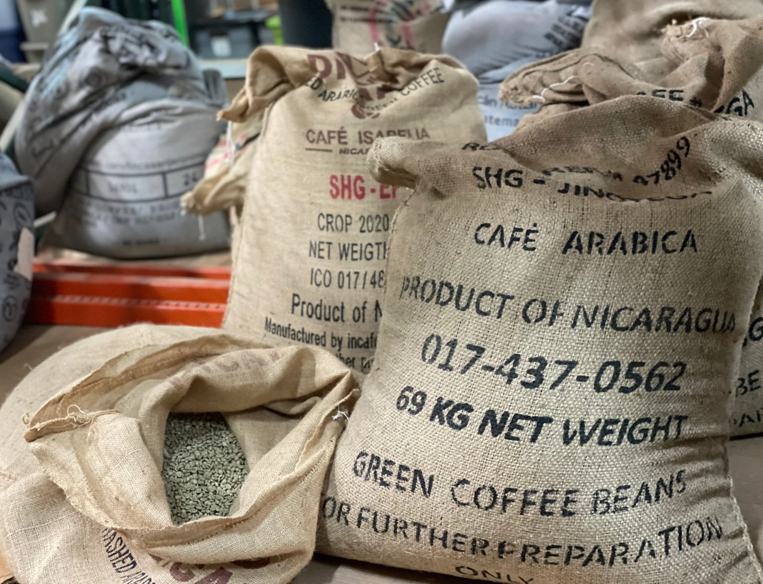 Bags of green coffee in burlap and denim sacks