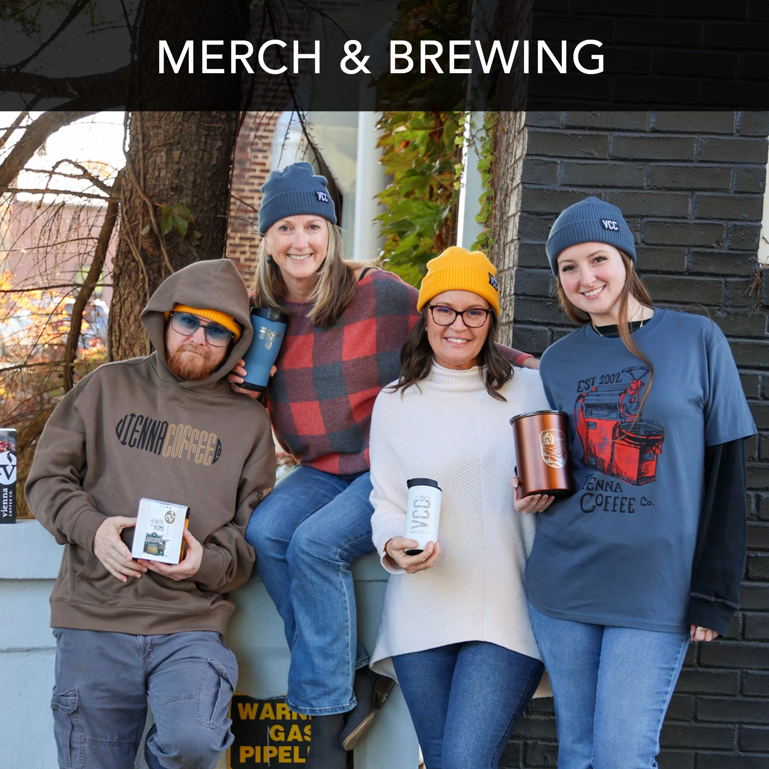 four people wearing Vienna Coffee Company merch and holding travel mugs and coffee bags