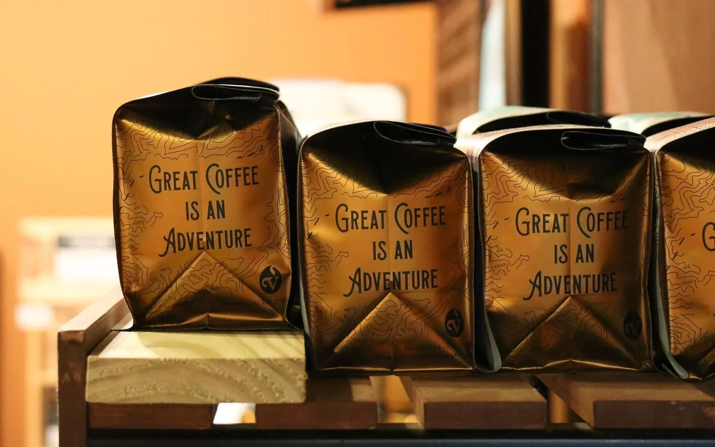 side view of Vienna Coffee Company bags with "great coffee is an adventure" tagline