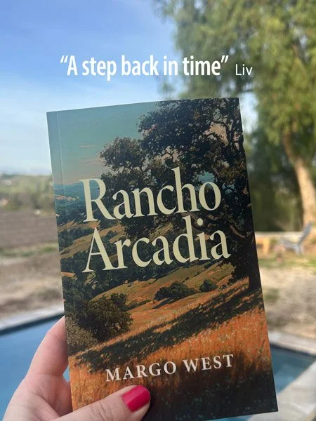 A person holding a book titled 'Rancho Arcadia' by Margo West outdoors, with trees and a clear sky in the background. The book features a landscape on its cover and quotes 'A step back in time' by Liv at the top.