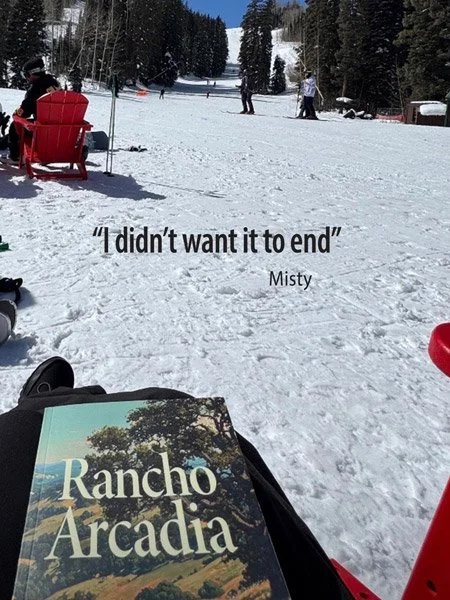 A snowy outdoor scene with people in the background, a red sled, and a book titled 'Rancho Arcadia' in the foreground. The image contains the quote 'I didn't want it to end' attributed to Misty.